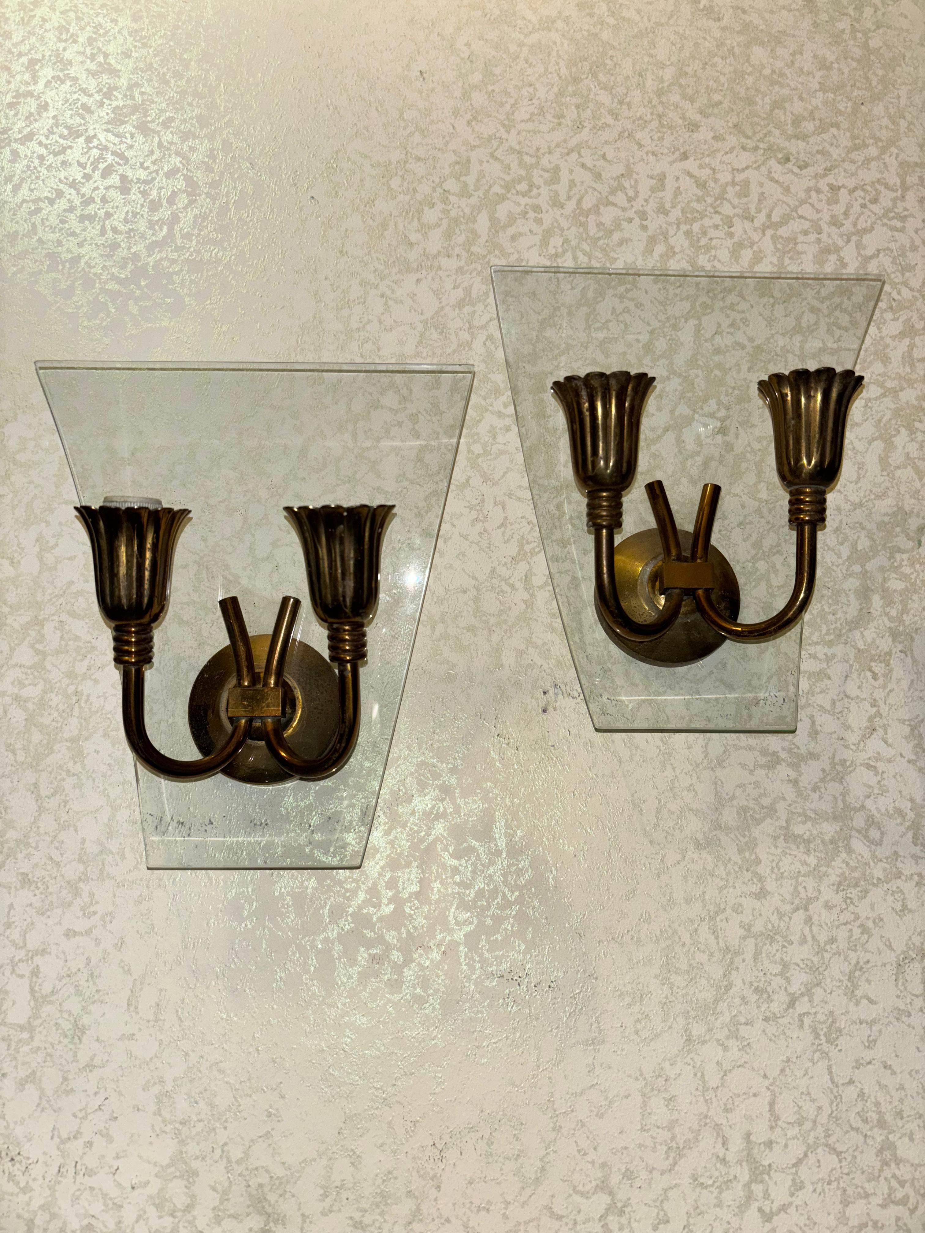 Pair of original wall sconces from the 1950s, from the quality of the brass and the elegant shape with wreath-like finials we can trace the designer who in this case from 'was Pietro Chiesa , when he worked at Fontana Arte where architect Gio Ponti