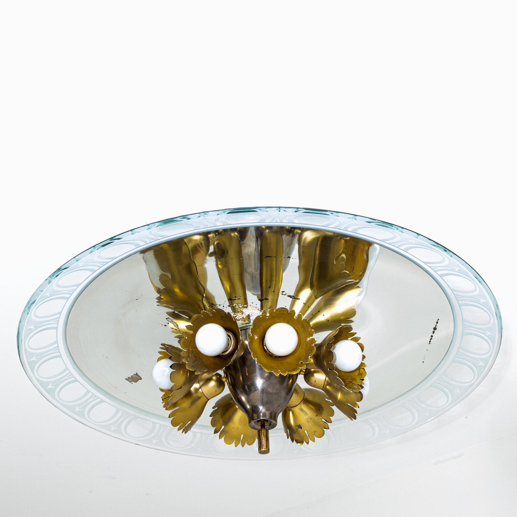 Ceiling lamp with bowl-shaped mirrored glass shade with decorative rim and leaf-shaped gold-patinated lampshades around the radially arranged sockets. The mirrored area with blind spots, the gold leaf shades are rubbed in places.