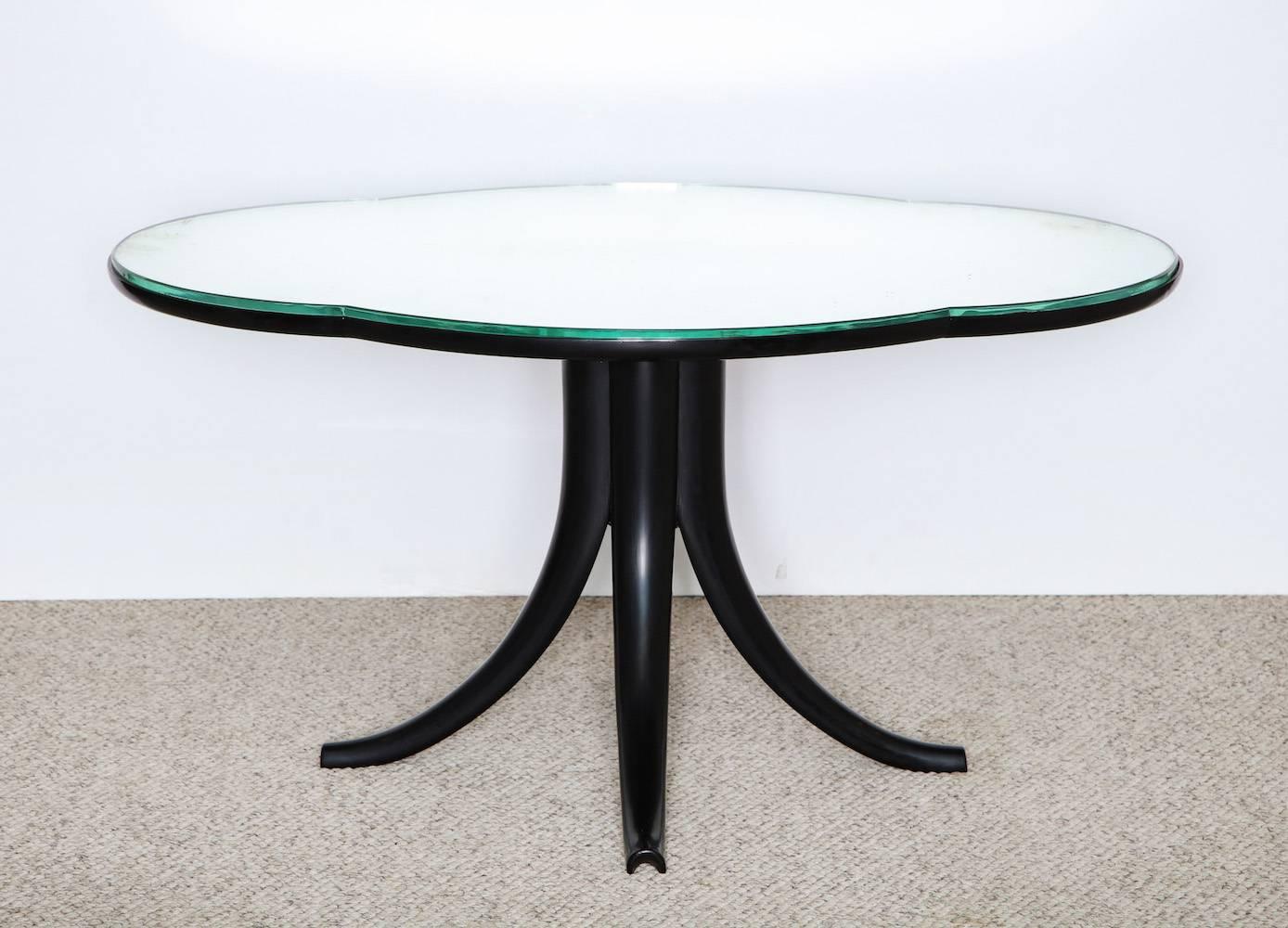 Rare and early cocktail table by Pietro Chiesa for Fontana Arte.
Elegant low table on pedestal base. Cloud-shaped top wood structure with thick mirrored set-in top. All wood elements are ebonized. Very good vintage condition. Wood has been touched