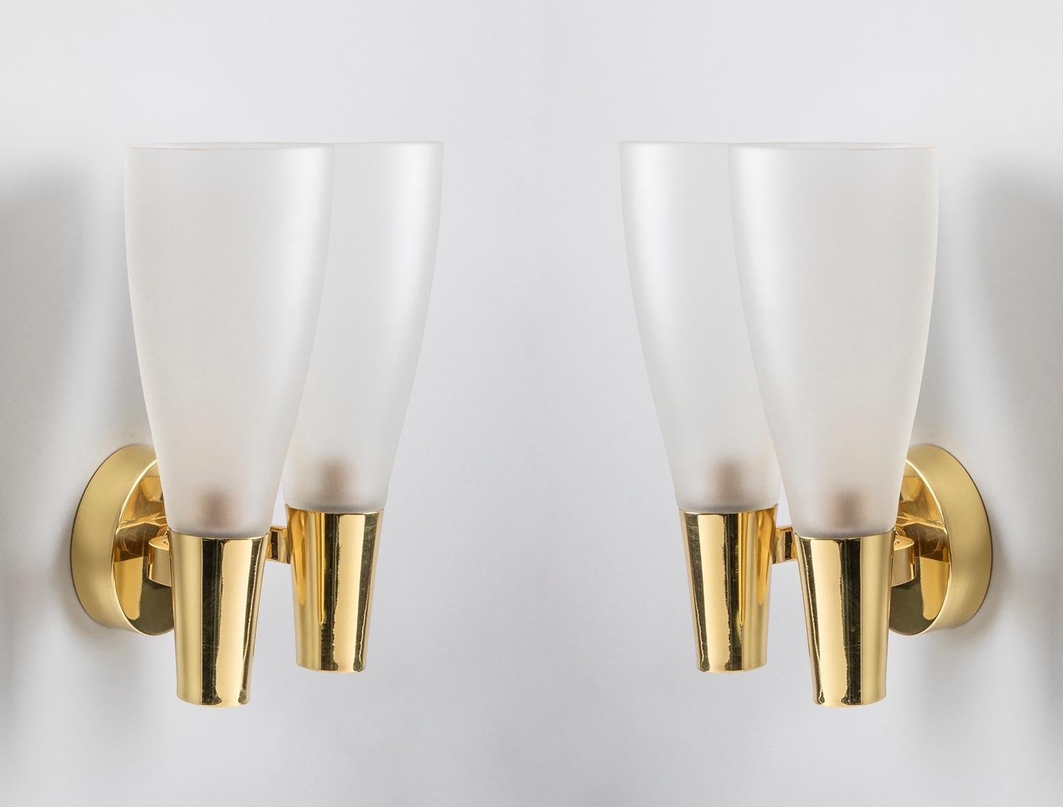 Pietro Chiesa (1892-1948) 

A refined and modern pair of sconces by modernist glass master Pietro Chiesa for Fontana Arte, with two tapered frosted glass shades supported by polished brass mounts anchored in a large, thick brass disk. Together,