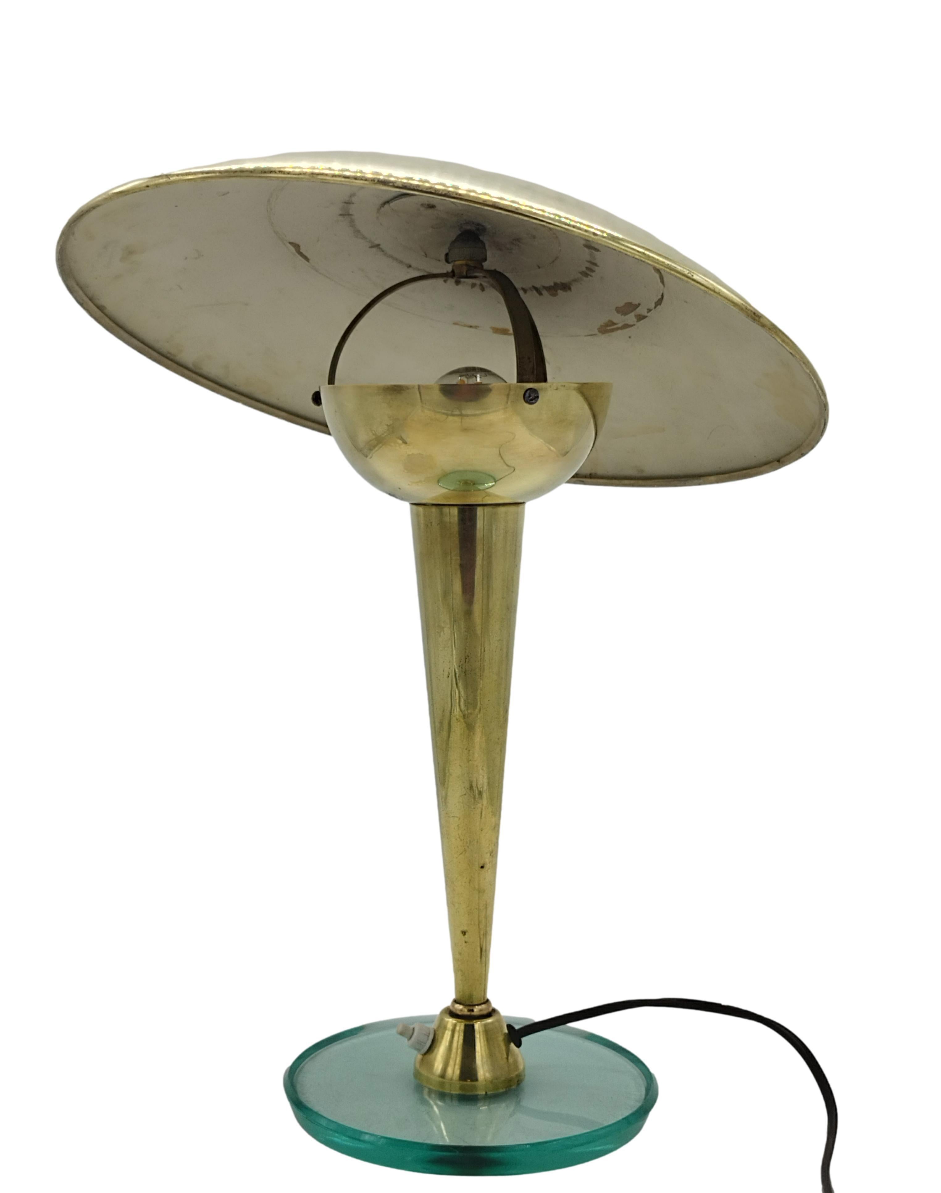 Fine and rare table lamp attributed to Pietro Chiesa for Fontana Arte, circa 1950. The lamp has a nile green crystal glass base and a tapered brass stem, adjustable jointed shade. Condition is good, brass is in patina, glass in perfect condition, in