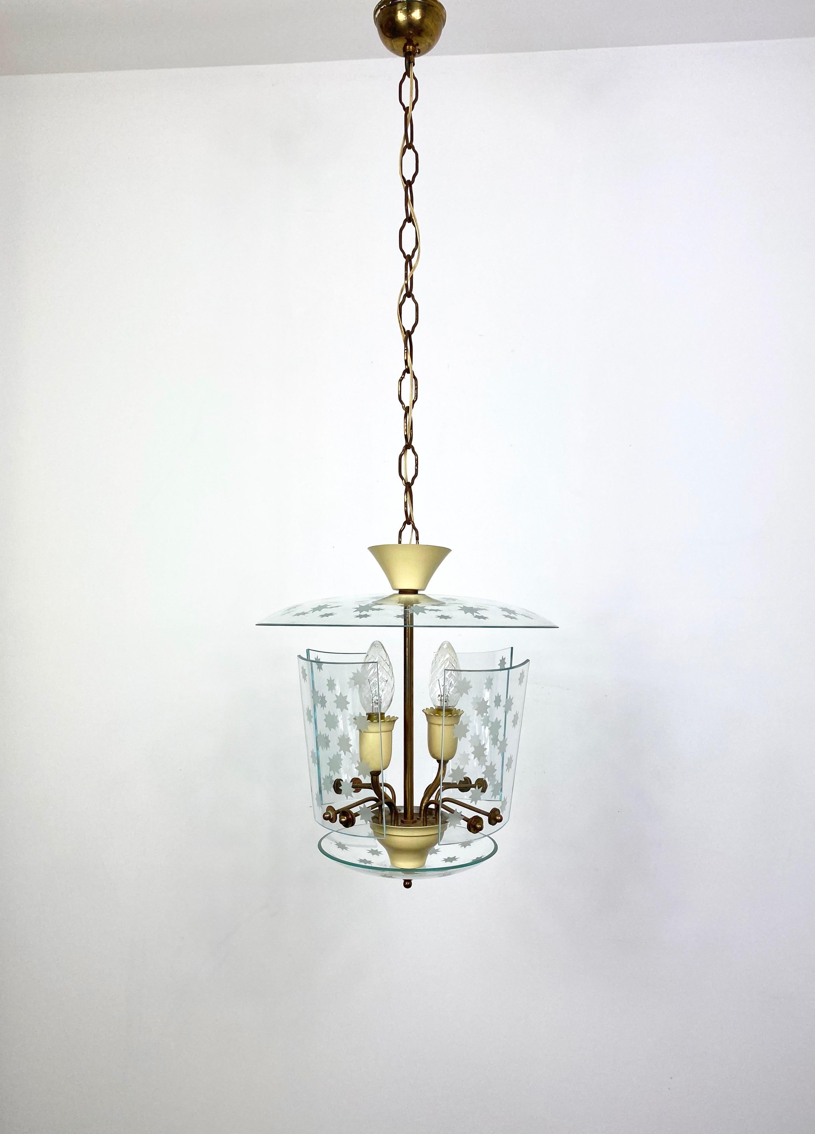 Chandelier lantern by the Italian eco designer Pietro Chiesa for Fontana Arte, circa 1950. Two-light with a glass structure embedded with incised stars on the surfaces and brass details.

Dimensions:
With pendant 90 height x 30 diameter
