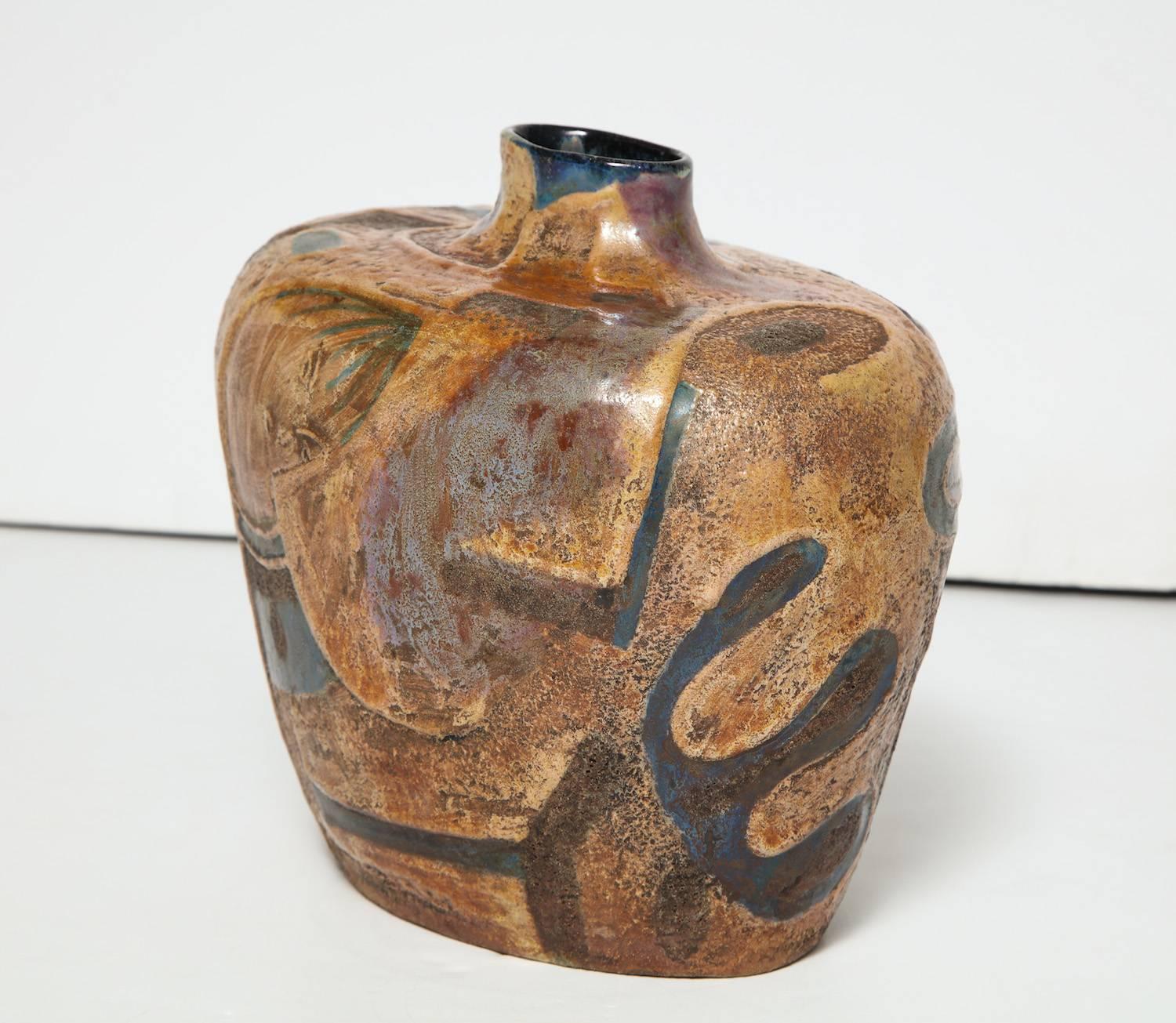 Studio-built vase by Pietro Melandri.
Irregular shaped vase with relief glazes in tans and blues depicting abstract figures. Signed on underside. A similar vase resides in the permanent collection of The International Museum of Ceramics, Faenza,