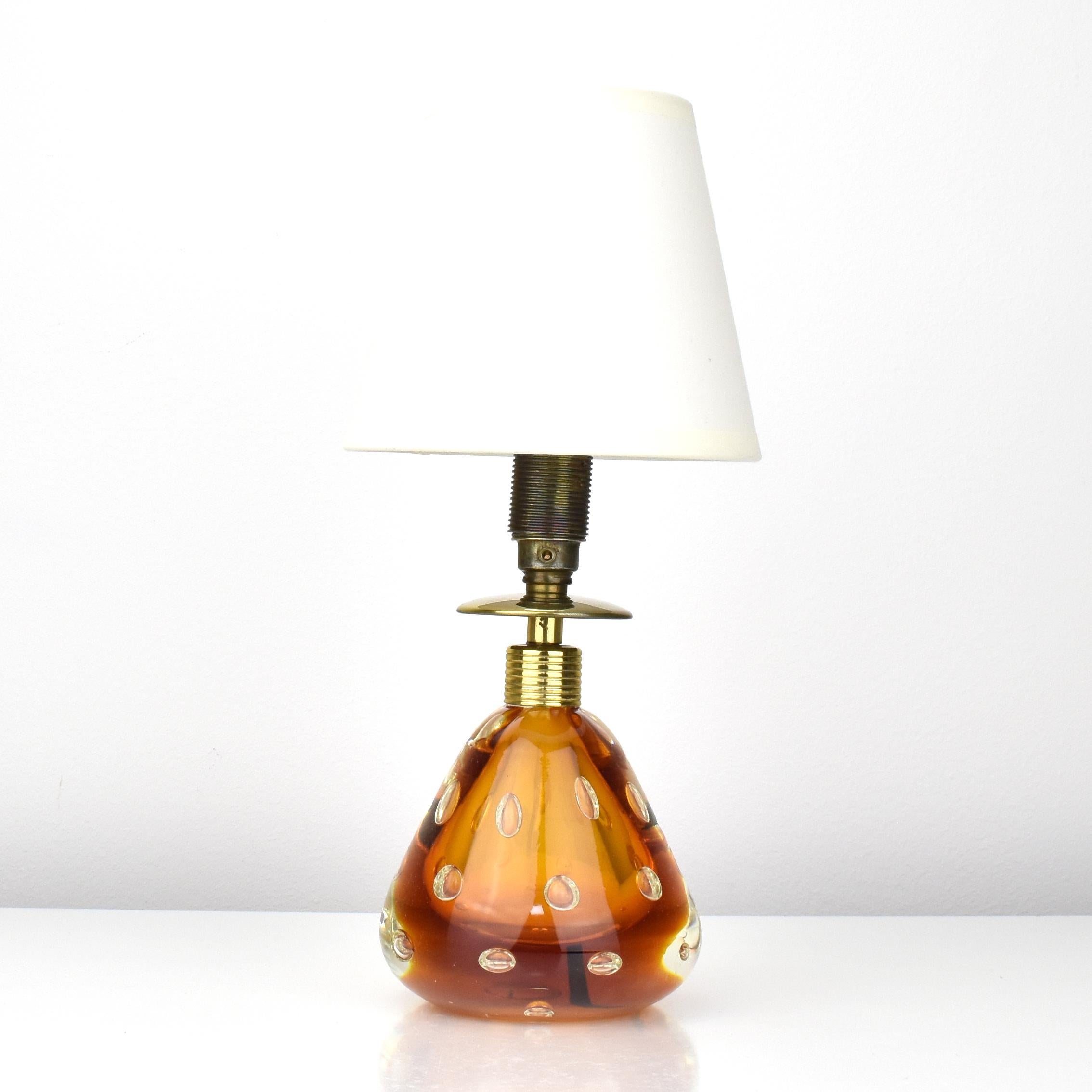 A cute small sized table lamp made of clear cased amber colored art glass with controlled bubbles in 