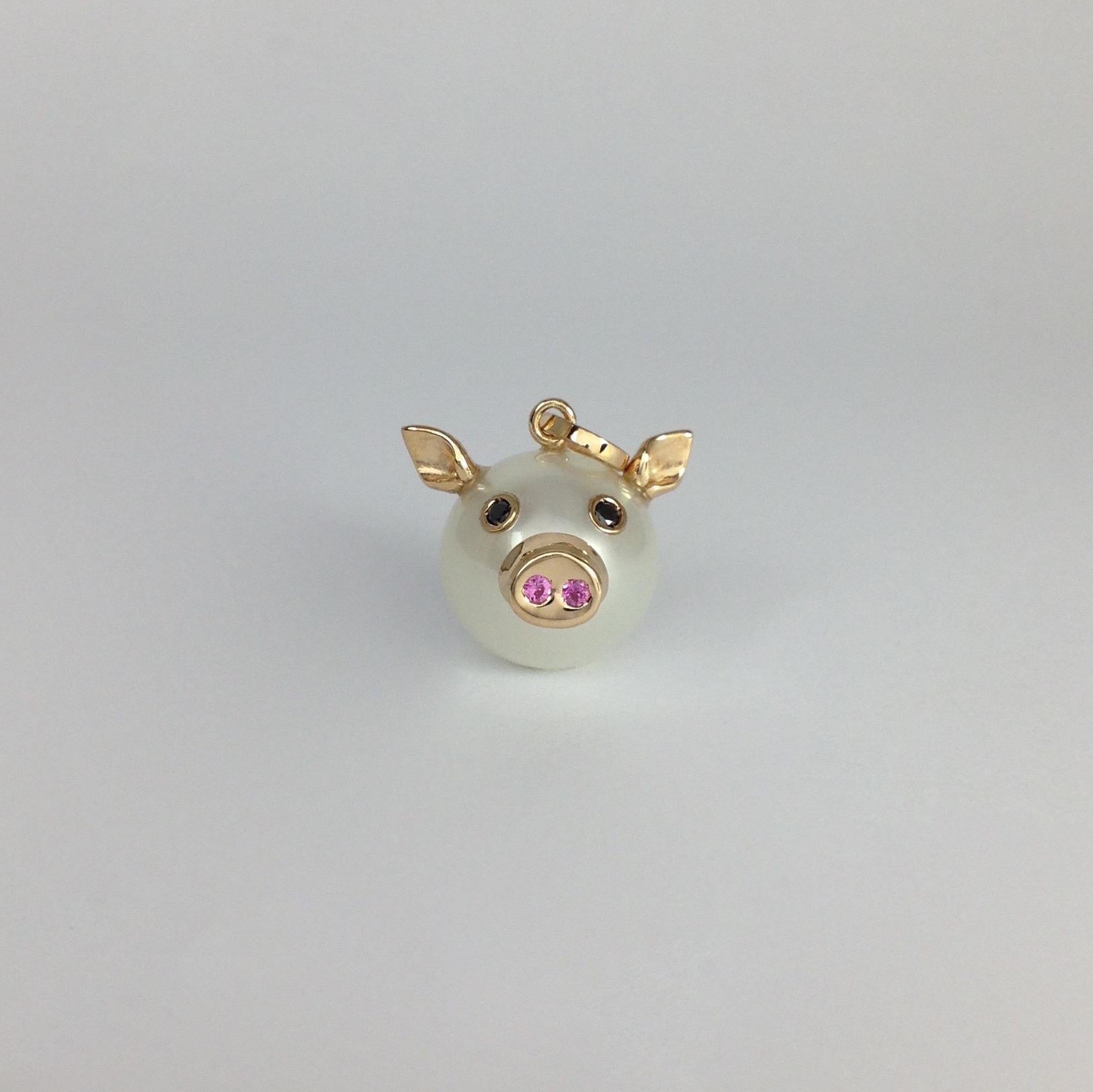 This nice pendant is made with a button Australian pearl. 
It has two ears, two eyes with black diamonds.  
In the holes of its nose there are two pink sapphires encrusted, in total ct 0.03.
All the particulars made in red gold.
The diamonds are in