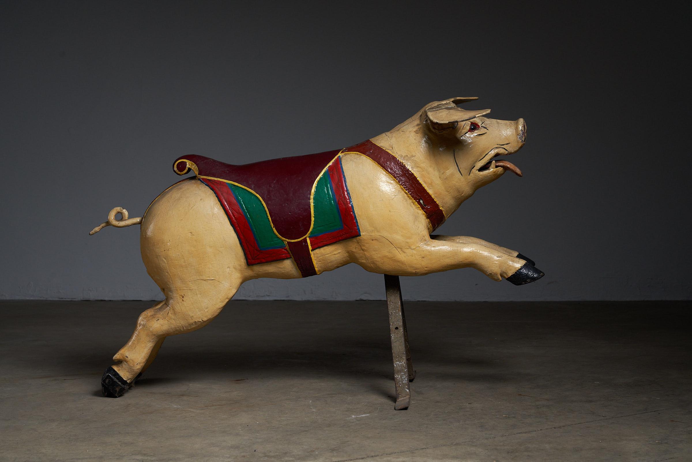 Add a touch of whimsy to your space with this charming antique carousel figure featuring a carved wooden pig. Crafted with precision and mounted on a sturdy metal base, this carousel piece showcases the craftsmanship of yesteryears. Perfect for