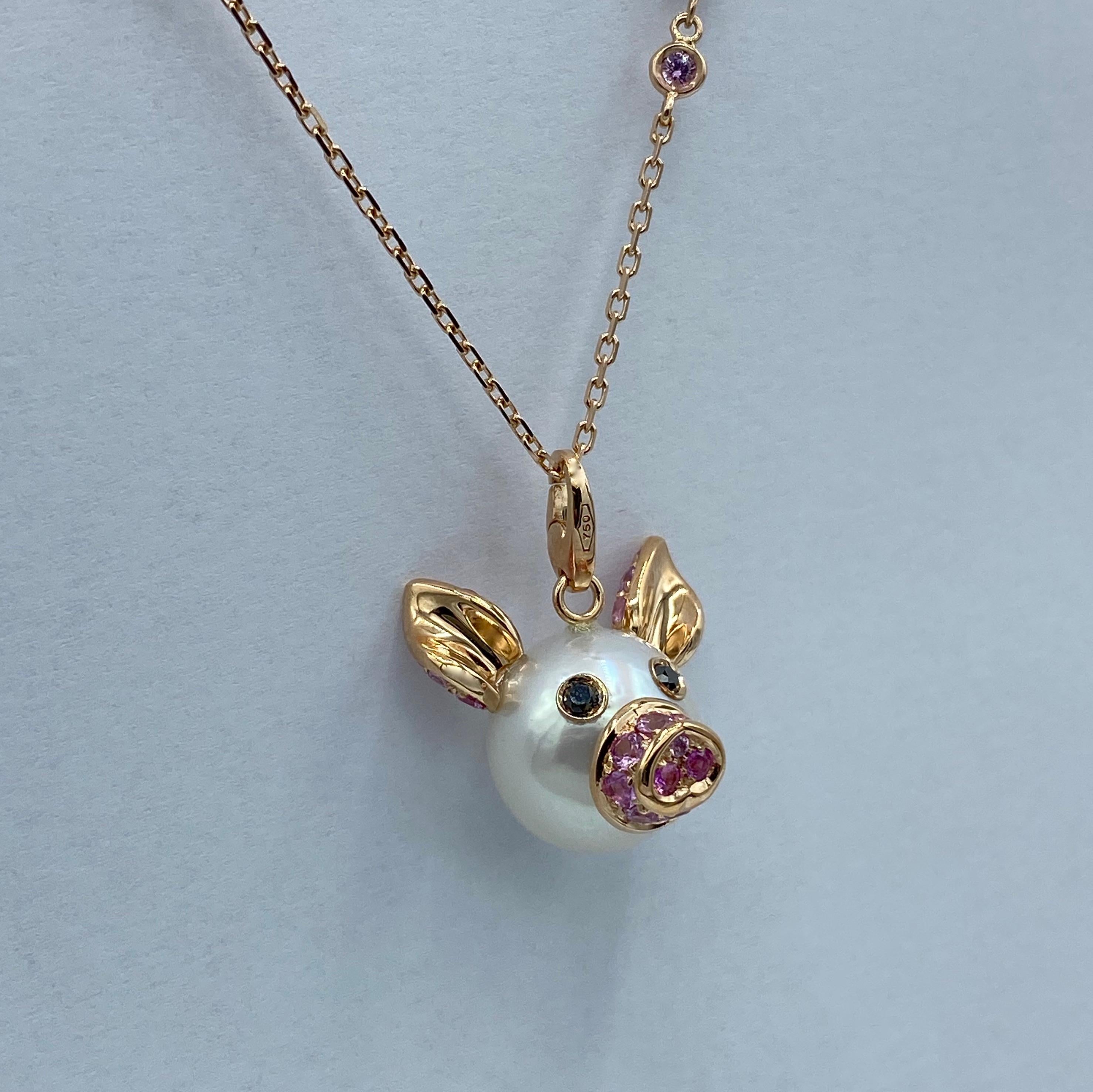 I created a fun pendant / charm using an Australian button pearl (diameter 13.8 mm) that represents the head of a piglet. It is embellished with a pavé of pink sapphires that cover the elements in pink gold: the ears and the nose.
The eyes consist