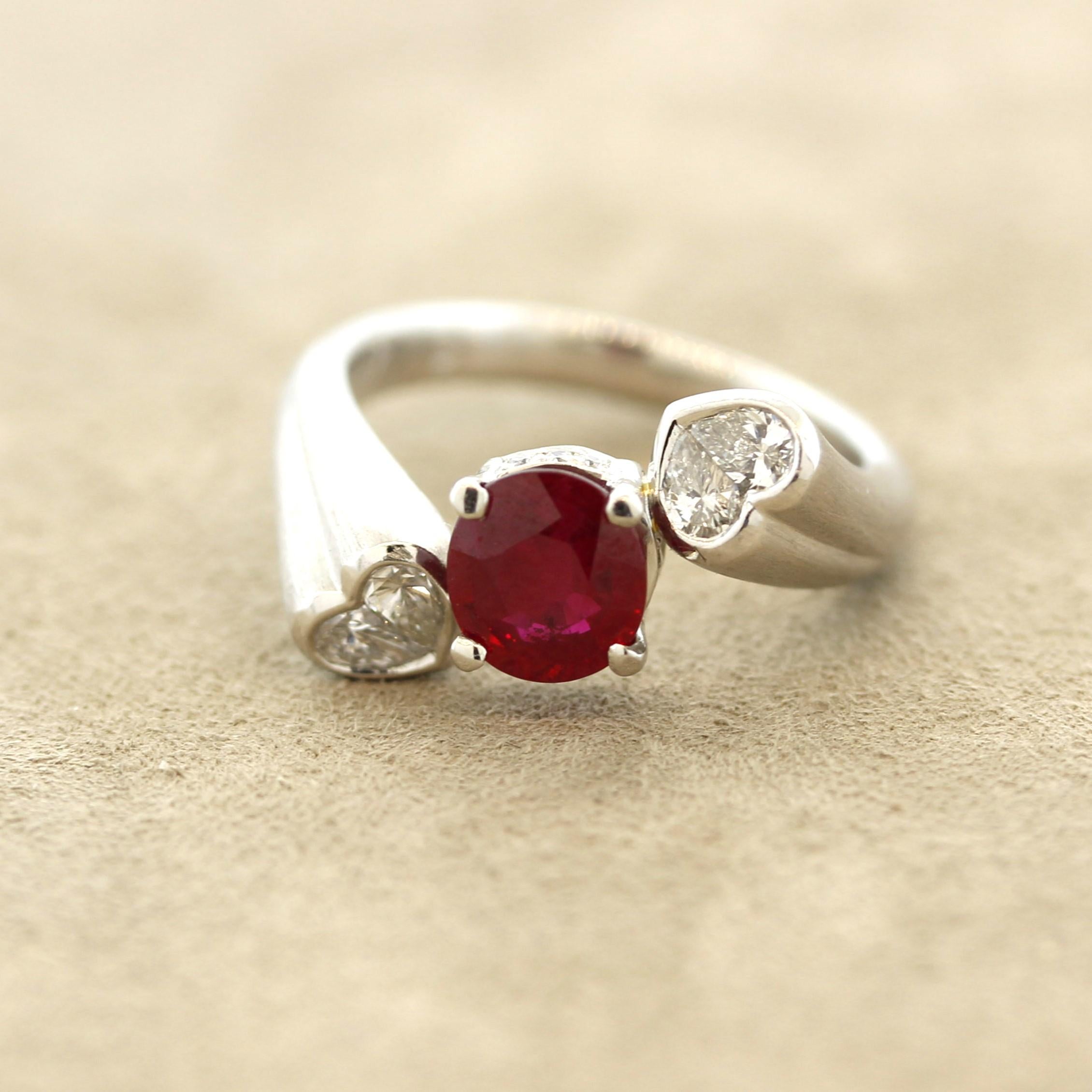 An intense fiery red ruby takes center stage weighing 1.26 carats. It has a rich vivid red color, which GIA refers to pigeon blood, that rivals any other stone on the market. It is complemented by 2 heart-shape diamonds set on its sides and weighing