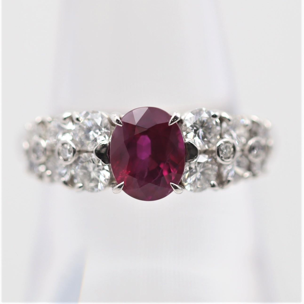 A fabulous 1.81 carat Burmese ruby takes center stage of this platinum ring. It has a fine vivid red color, allowing the laboratory to type it as “pigeons blood” color, a term used for the finest color rubies in the trade. It is complemented by 1.00