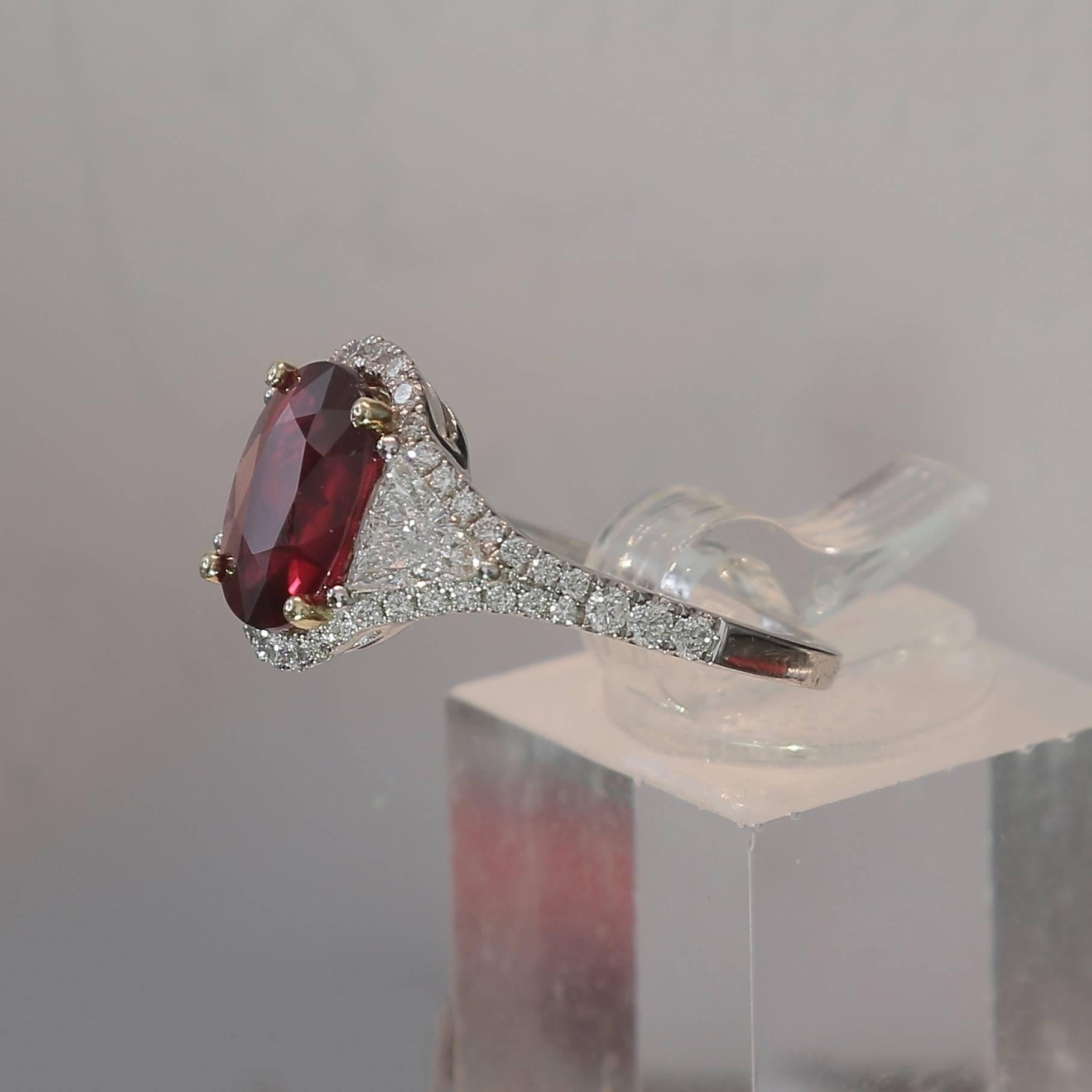 An amazing Pigeon's Blood Ruby Ring weighing 3.04 carats. 
The stone’s shape is oval, having for colors a striking Pigeon Blood color (Vivid Red). 
The ring is adjoined with two Troidia Diamond weighing 0.64 Carats and 48 Round Diamonds weighing