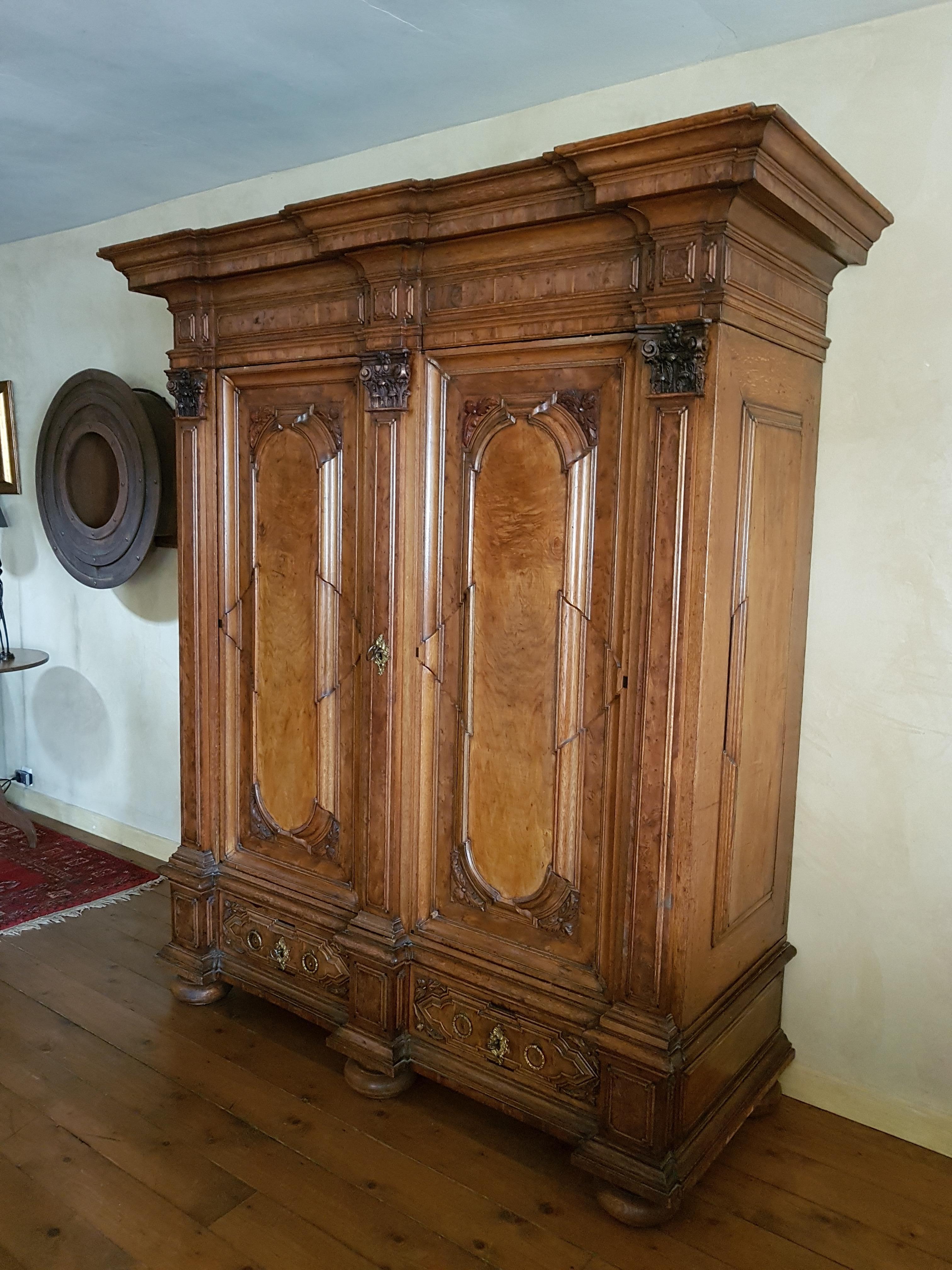 Pilasterschrank 18. Jahrhundert
MAINFRANKEN, 

NUSSBAUM SOWIE EICHE U. A. HÖLZER, FURNIERT
ZWEITÜRIGER DURCH PILASTER MIT GESCHNITZTEN KAPITELLEN GEGLIEDERTER KORPUS ZWEISCHÜBIGEM SOCKEL UND VERKRÖPFTEM KRANZ AUF 5 BALLENFÜSSEN
RELIEFIERTER FLORALER