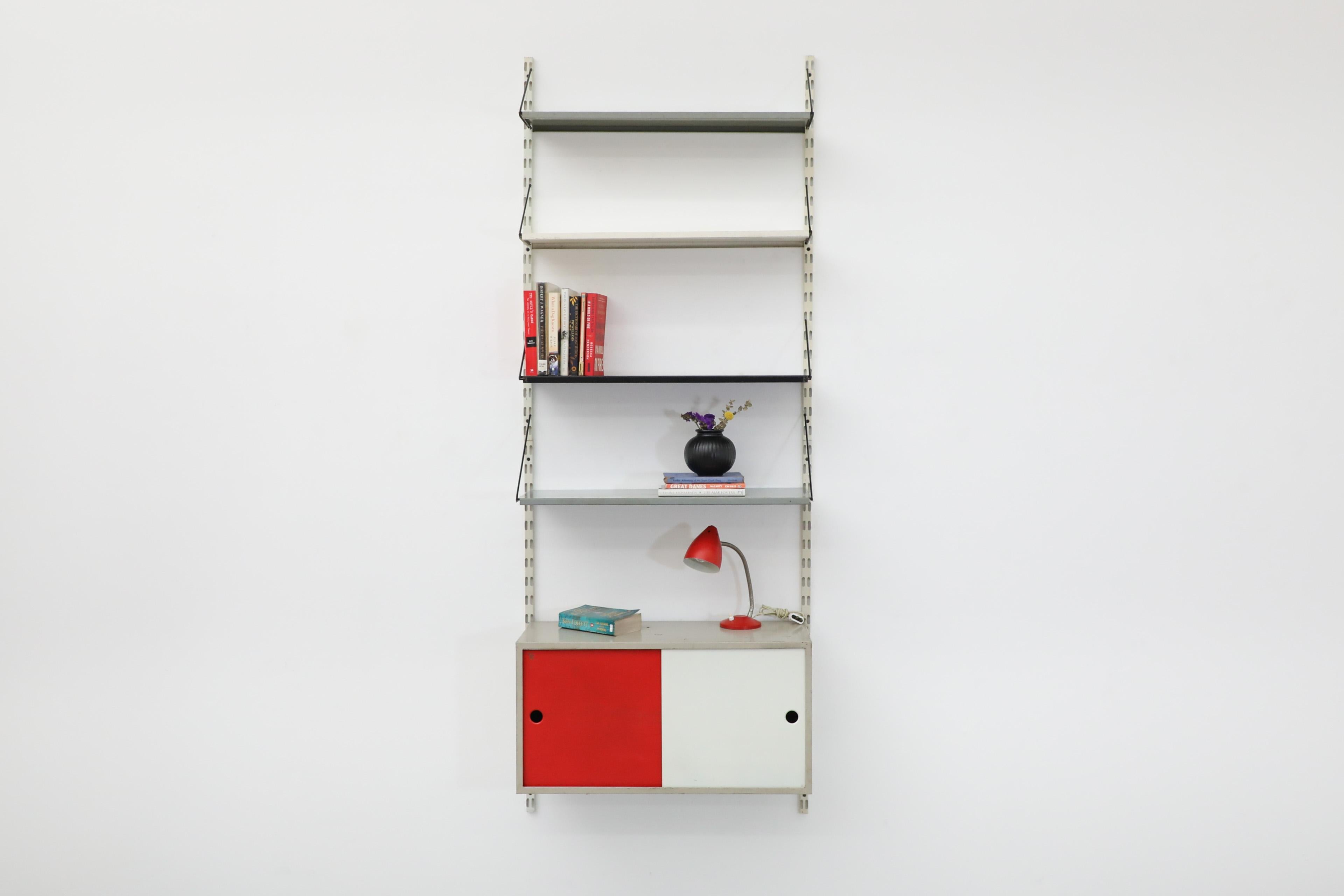 Pilastro adjustable and re-arrangeable industrial metal wall mounted shelving unit with red and white cabinet. Comes with four shelves, two gray, one white and one black with four risers which can be stacked vertically or horizontally. The unit