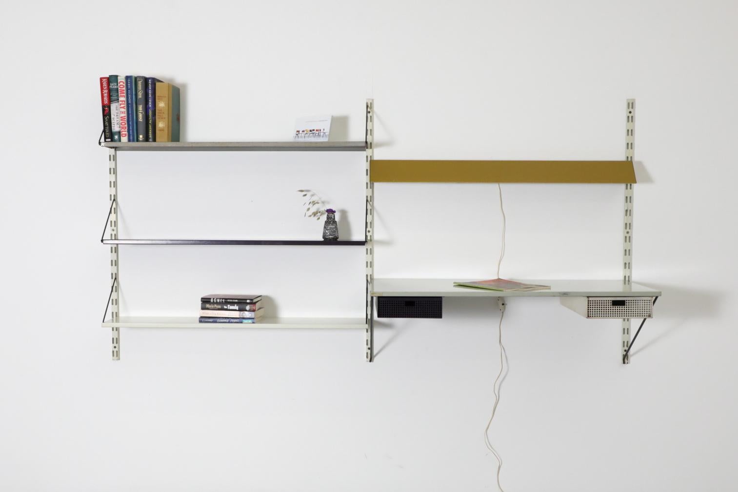 Estantería holandesa de mediados de siglo, de metal esmaltado Pilastro, montada en la pared. Este mueble tiene un escritorio (o tocador) esmaltado en gris con cajones perforados en blanco y morado, una luz de escritorio de doble bombilla mostaza y