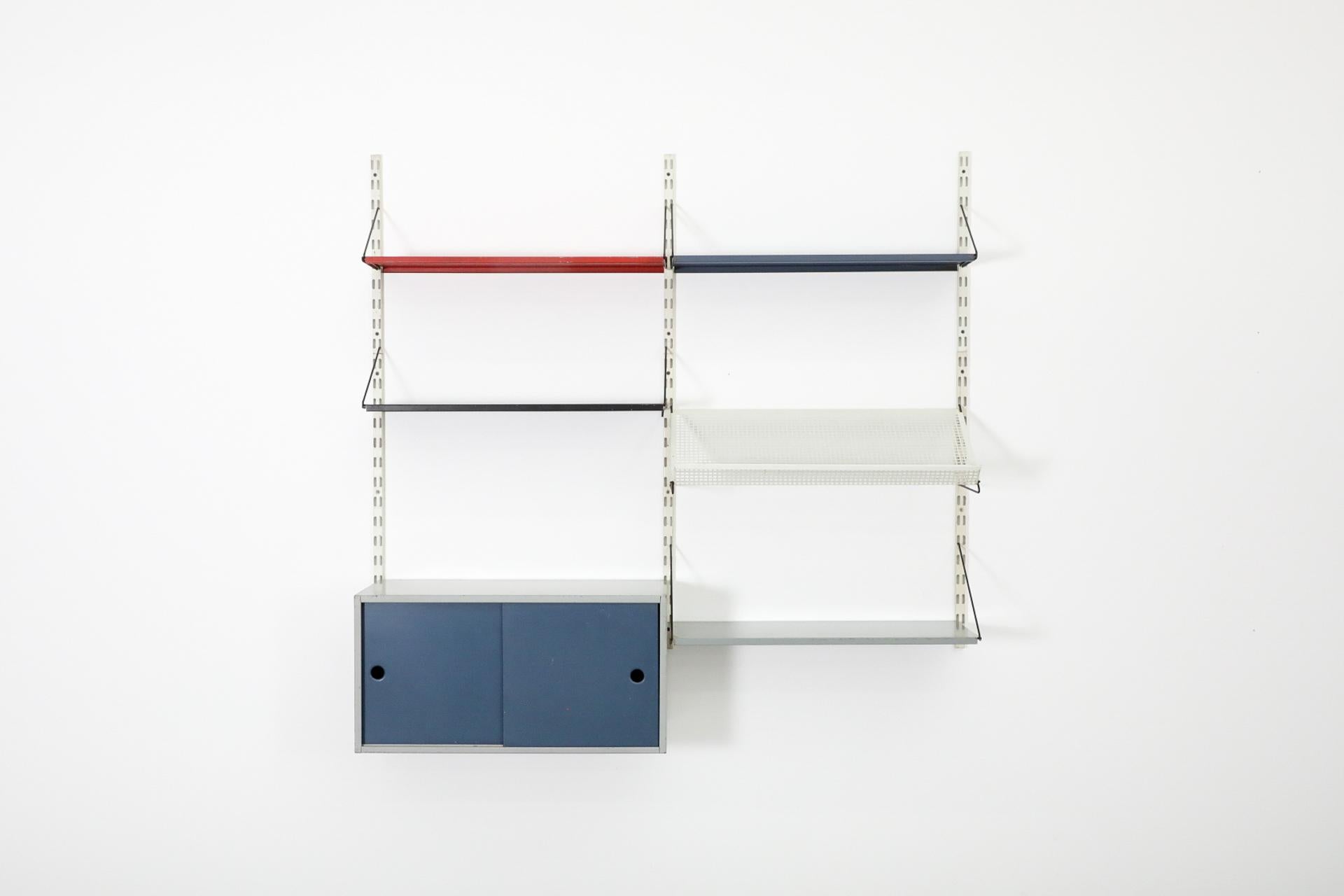 Pensile olandese del Mid-Century, prodotto da Pilastro, con un mobile rosso e blu, quattro ripiani in grigio, nero, rosso e blu e un porta riviste o libri traforato bianco. Ogni pezzo è completamente regolabile e può essere disposto in più modi.