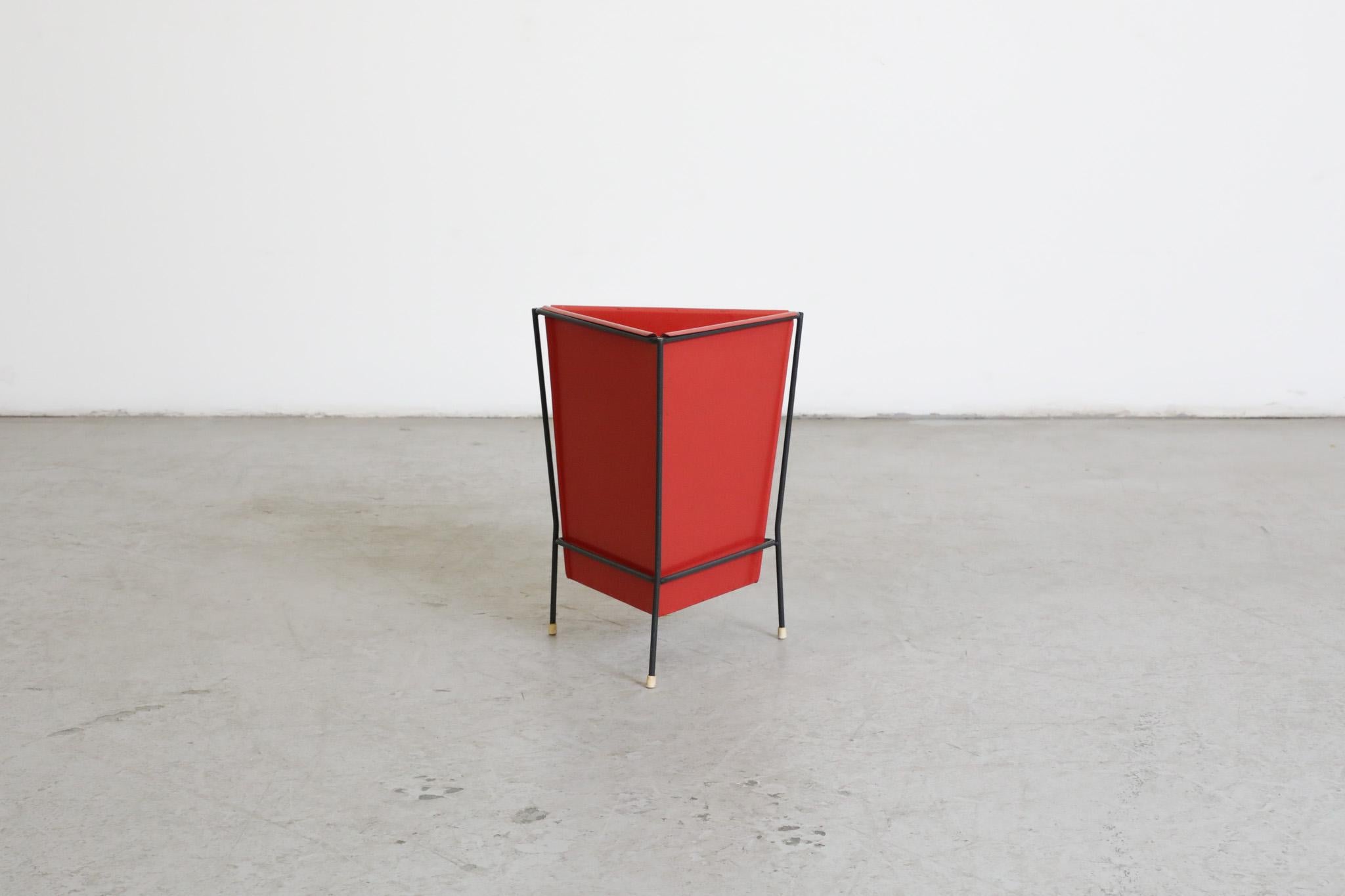 Dutch, Mid-Century, red enameled metal triangle bin with black frame by Dutch post-war furniture and home goods manufacturer Pilastro. Produced in the 1950's and in original condition with visible wear, including some paint loss and discoloration on