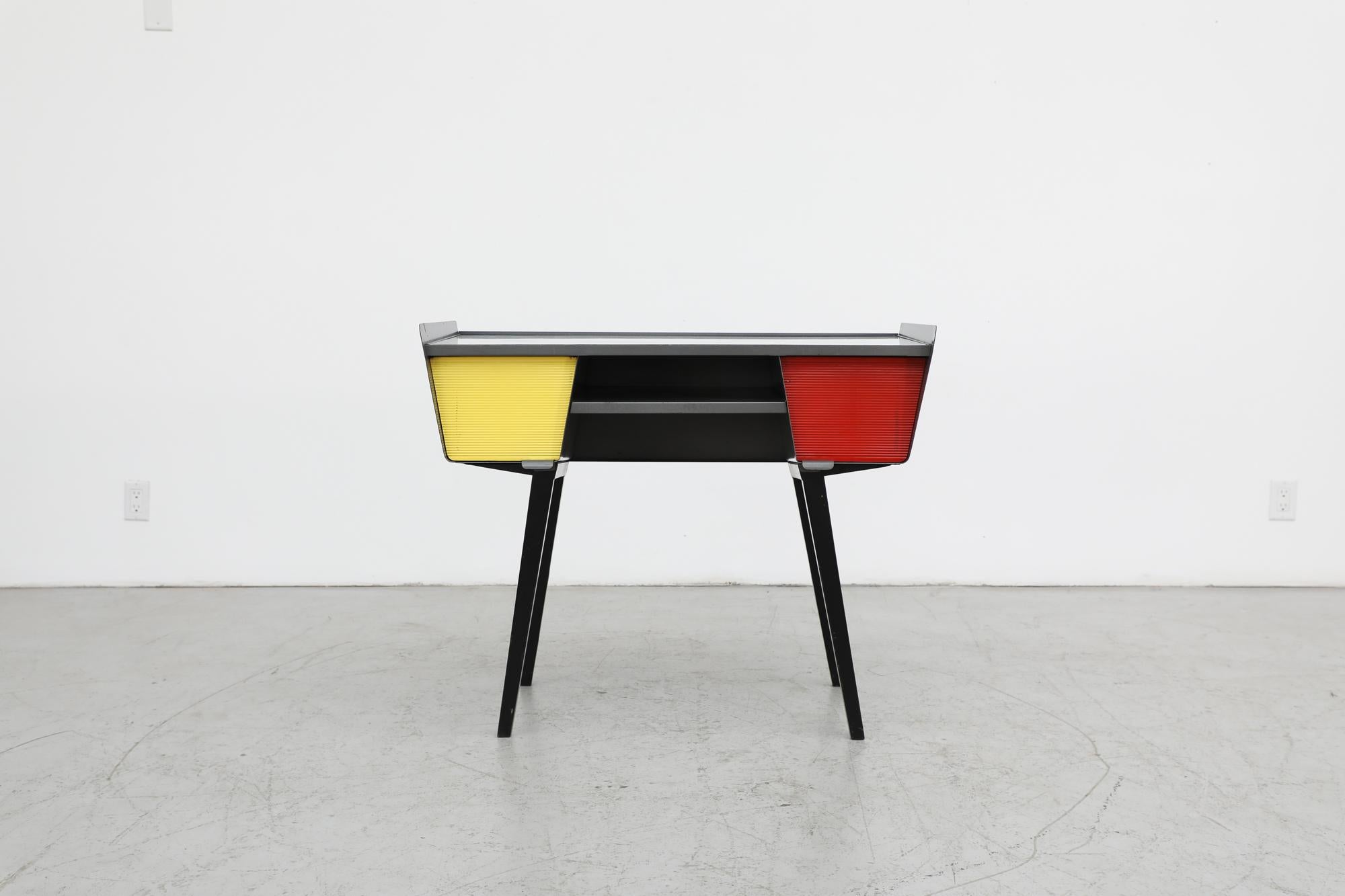 Colorful and wonderfully designed, 1950s Mid-Century industrial writing desk. A stunning example of Dutch post-war design with slightly angled black enameled legs and a gray metal frame. A generously sized laminate top houses a lower storage shelf