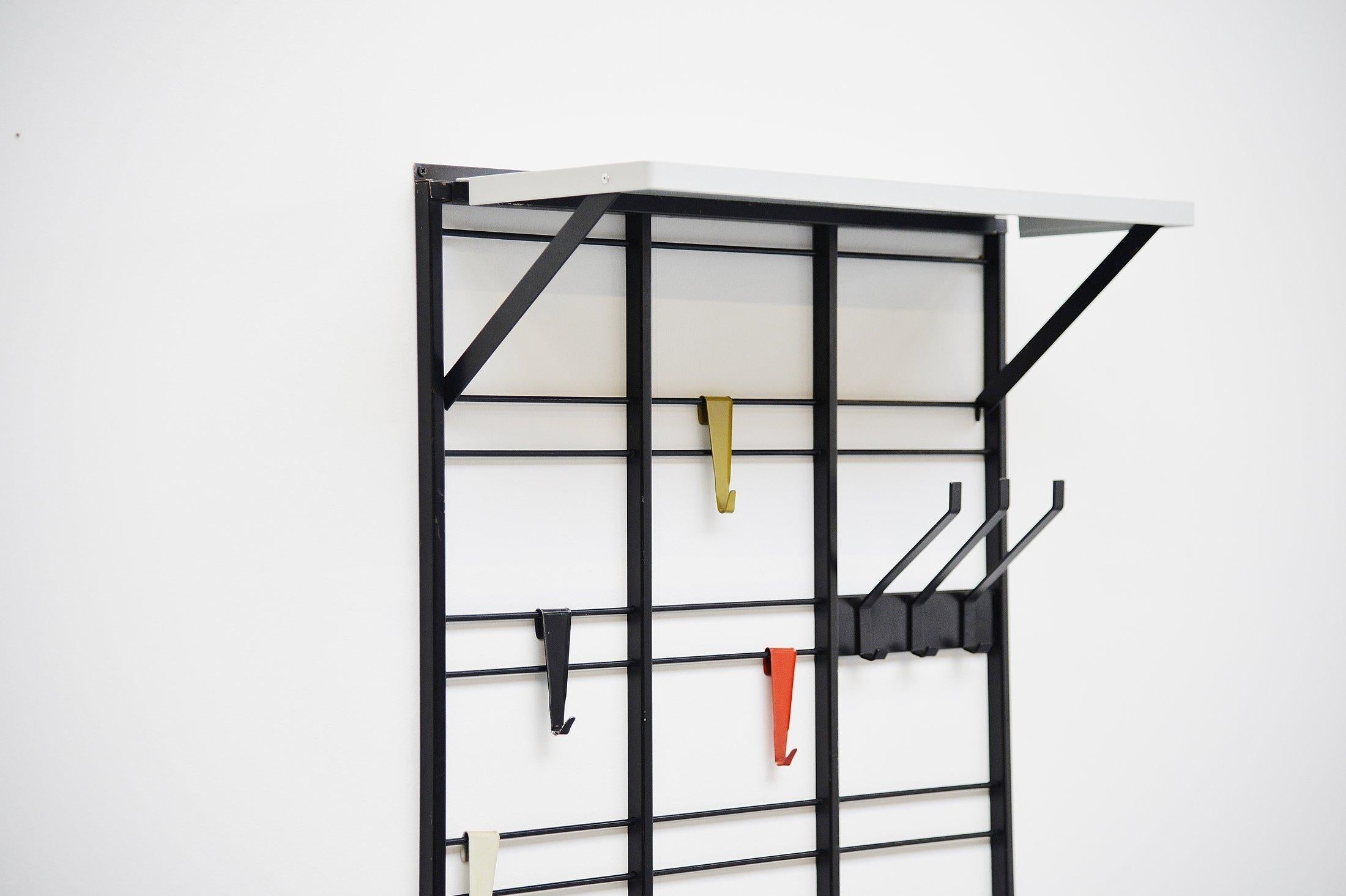Fantastic shaped ‘Servo Muto’ wall mounted coat rack designed by Tjerk Reijenga and manufactured by Pilastro, Holland 1960. This coat rack is made of black painted metal and has 12 colored metal coat hooks in white, black, green and red. This is for