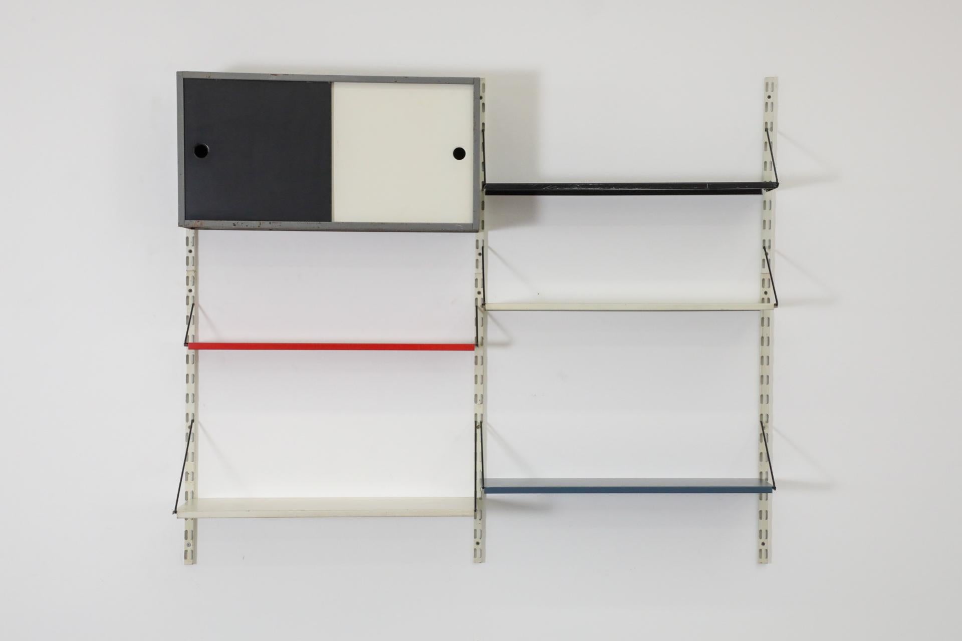 Scaffale in metallo smaltato olandese di metà secolo, Pilastro, con armadio. Questa unità presenta un mobile in metallo grigio con ante scorrevoli smaltate in bianco e nero e 5 ripiani in metallo di colori assortiti. Negli anni '50 e '60, Pilastro,