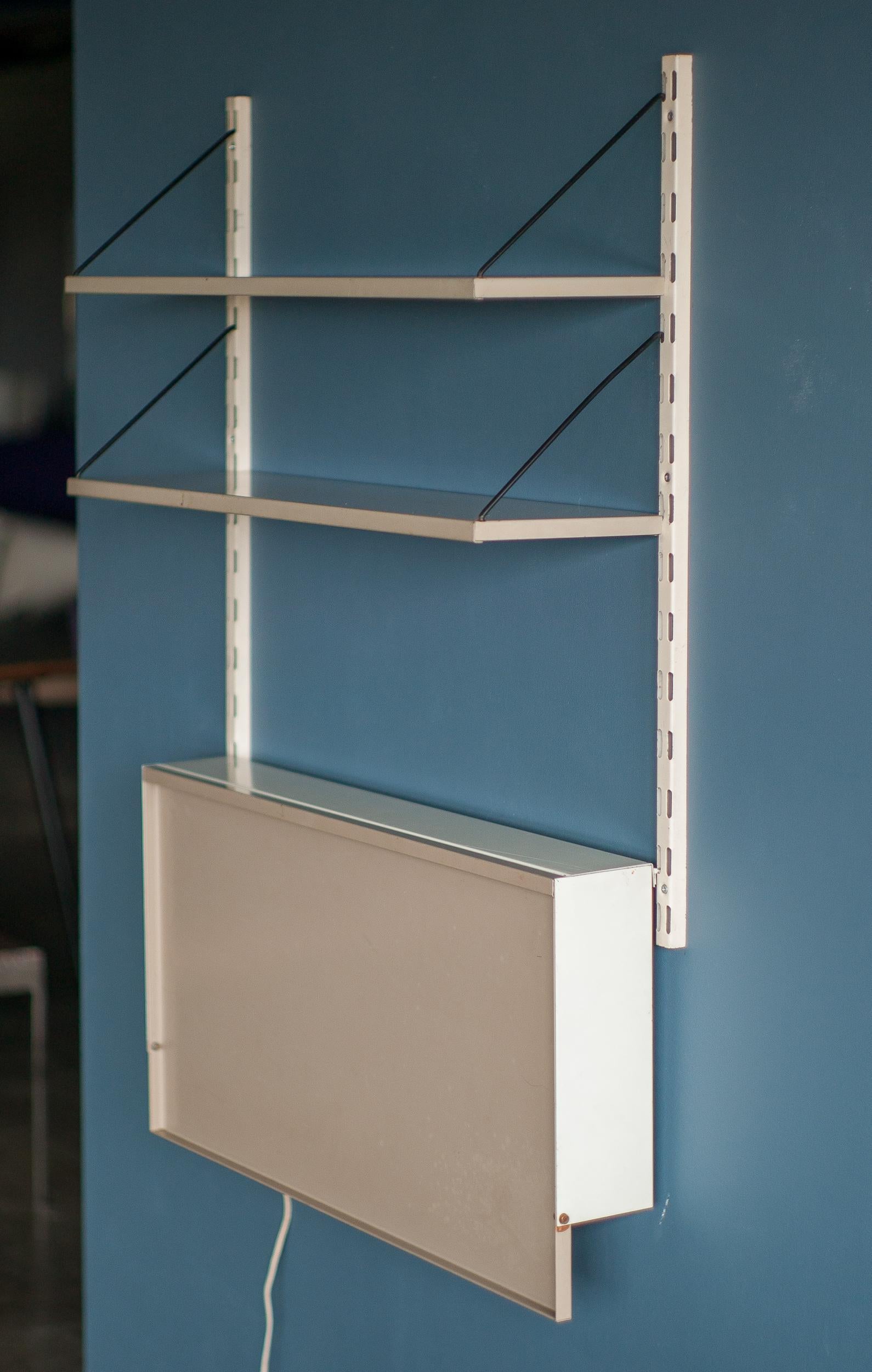 Minimalist wall system designed by Reijenga for Pilastro, The Netherlands.
Two shelves and a drop down desktop in beige.
The desk has a hidden light behind front panel.
Mid Century Modern space saving design.