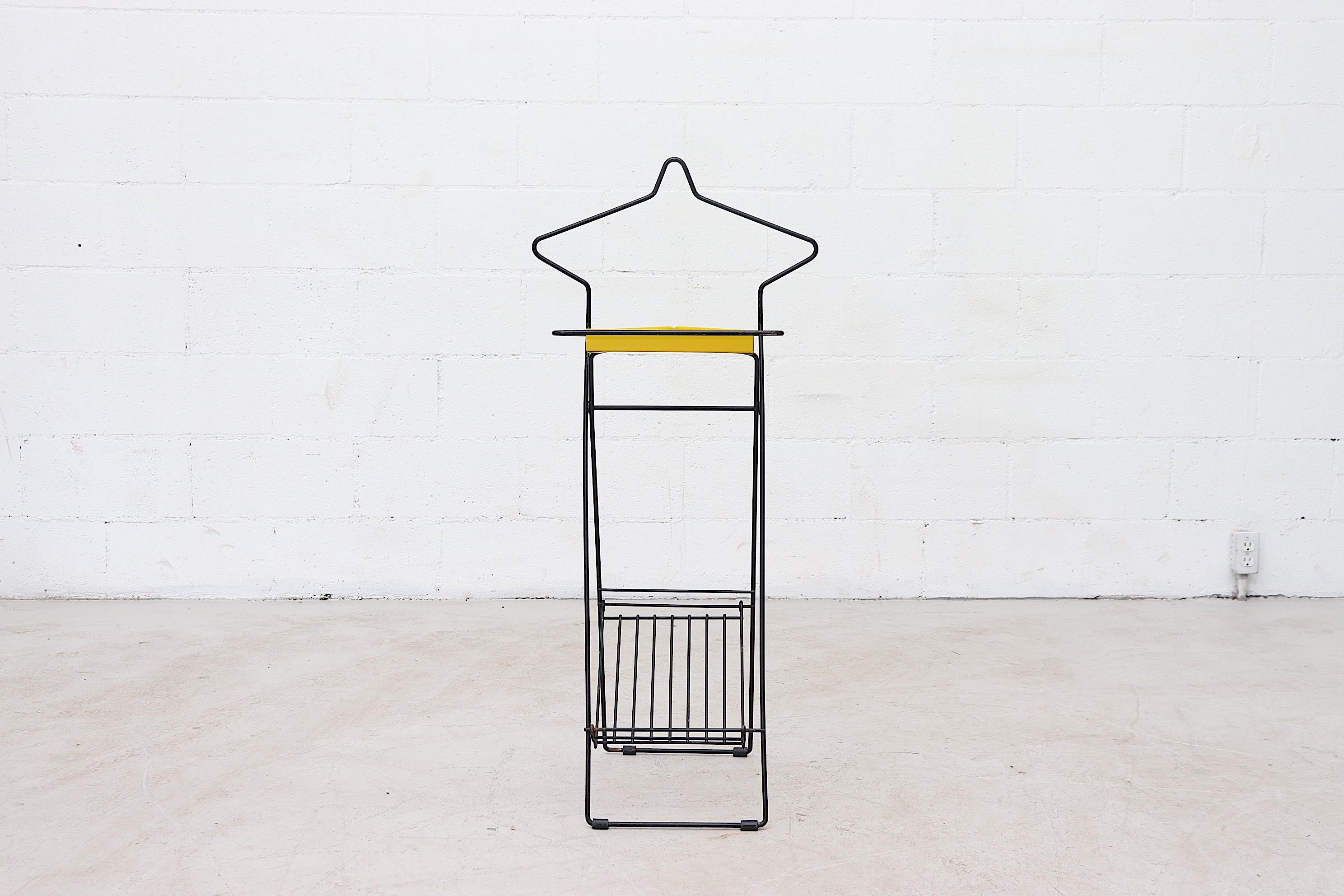 Black wire framed industrial style valet with removable yellow accessory tray and shoe rack. Light weight and collapsible with a striking design.