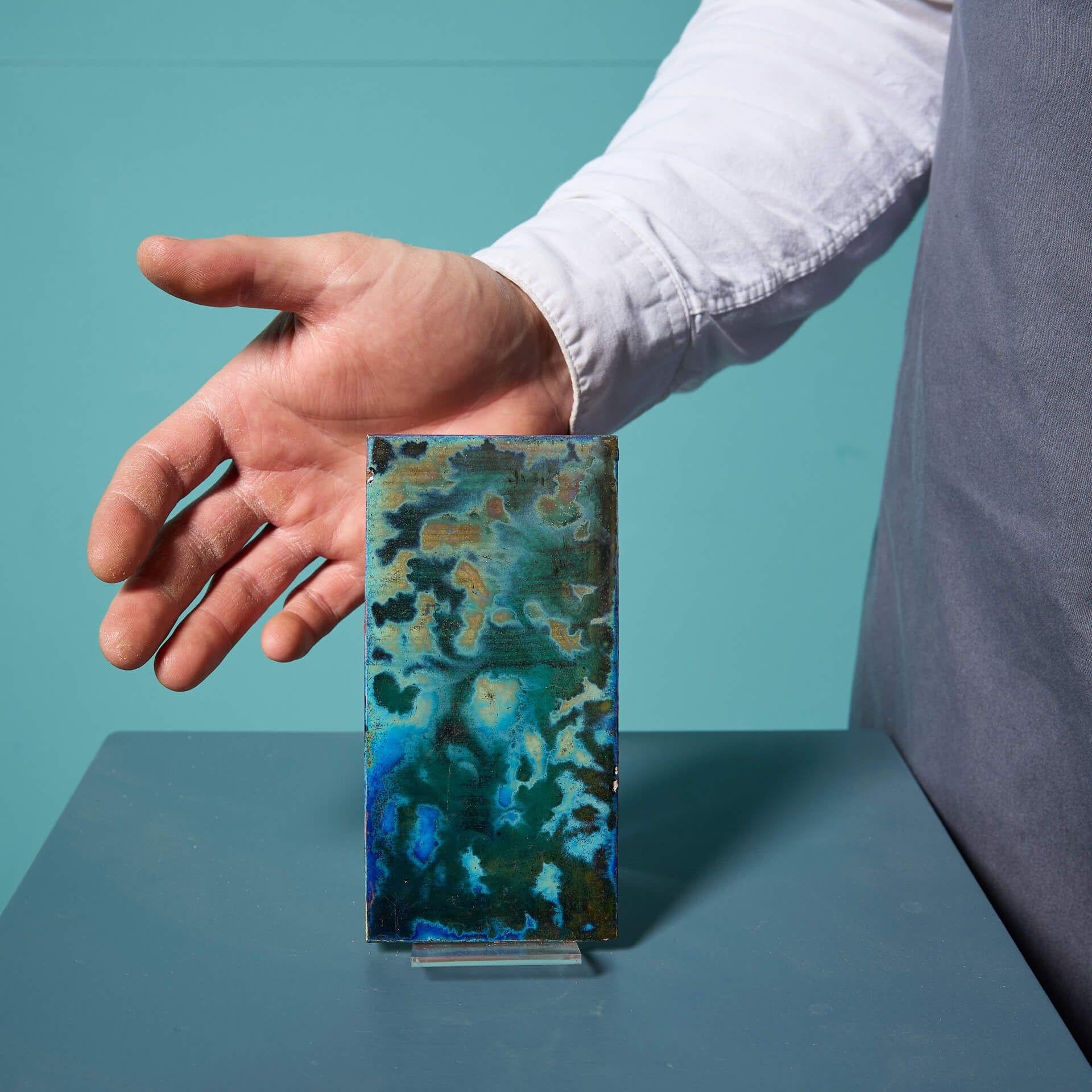 Un carreau décoratif de 6 pouces sur 3 pouces à glaçure lustrée antique de Pilkington's Tile and Pottery Co.

Datant du début du XXe siècle, ce carreau inhabituel est artistiquement décoré d'une glaçure à effet d'ombre bleu-vert, qui lui donne un