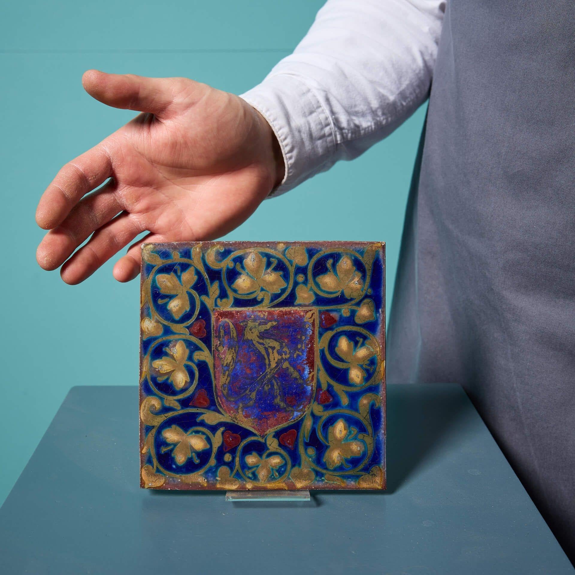 A decorative 6-inch heraldic blue lustre tile by Pilkington, circa 1915, impressed with a single ‘P’ to the reverse.

Decorated with a beautiful lustre glaze, this antique English tile is detailed with a striking contrast of royal blue colour and