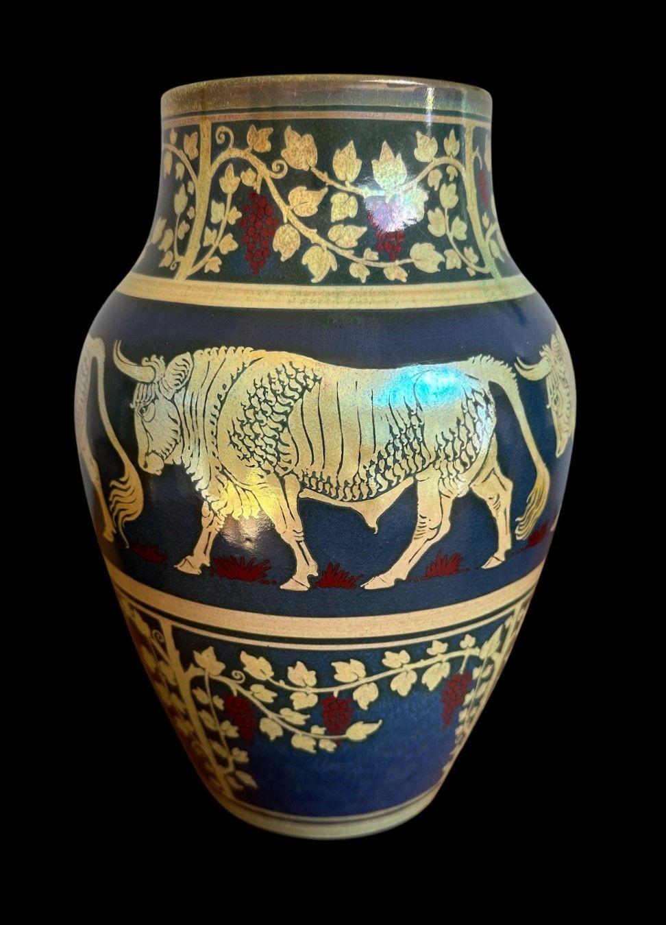 5486
Large Pilkington’s Royal Lancastrian Lustre Vase with a superb firing, decorated with Bulls between a band of grapevines by Richard Joyce.
27cm high, 18cm wide
Glaze frit to the footrim
Date cypher for 1910