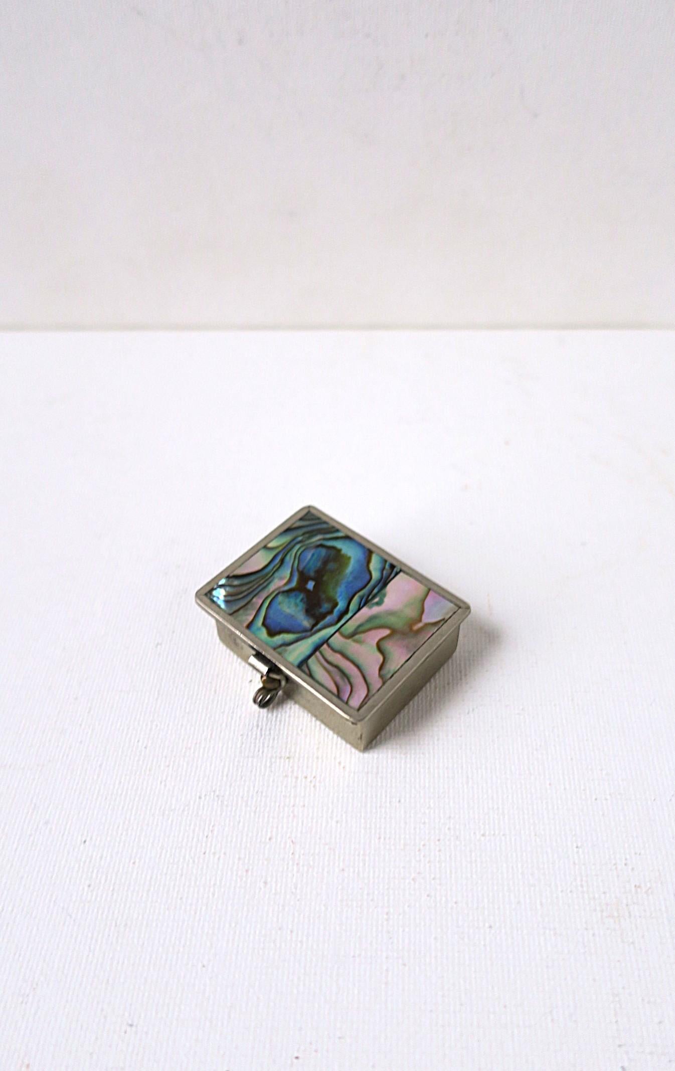 Portapillole in conchiglia abalone e metallo alpaca, realizzato a mano, circa 1960, metà del XX secolo, Messico. La scatola è rettangolare con una bellissima conchiglia iridescente; la parte superiore è incernierata con chiusura frontale. Marcato