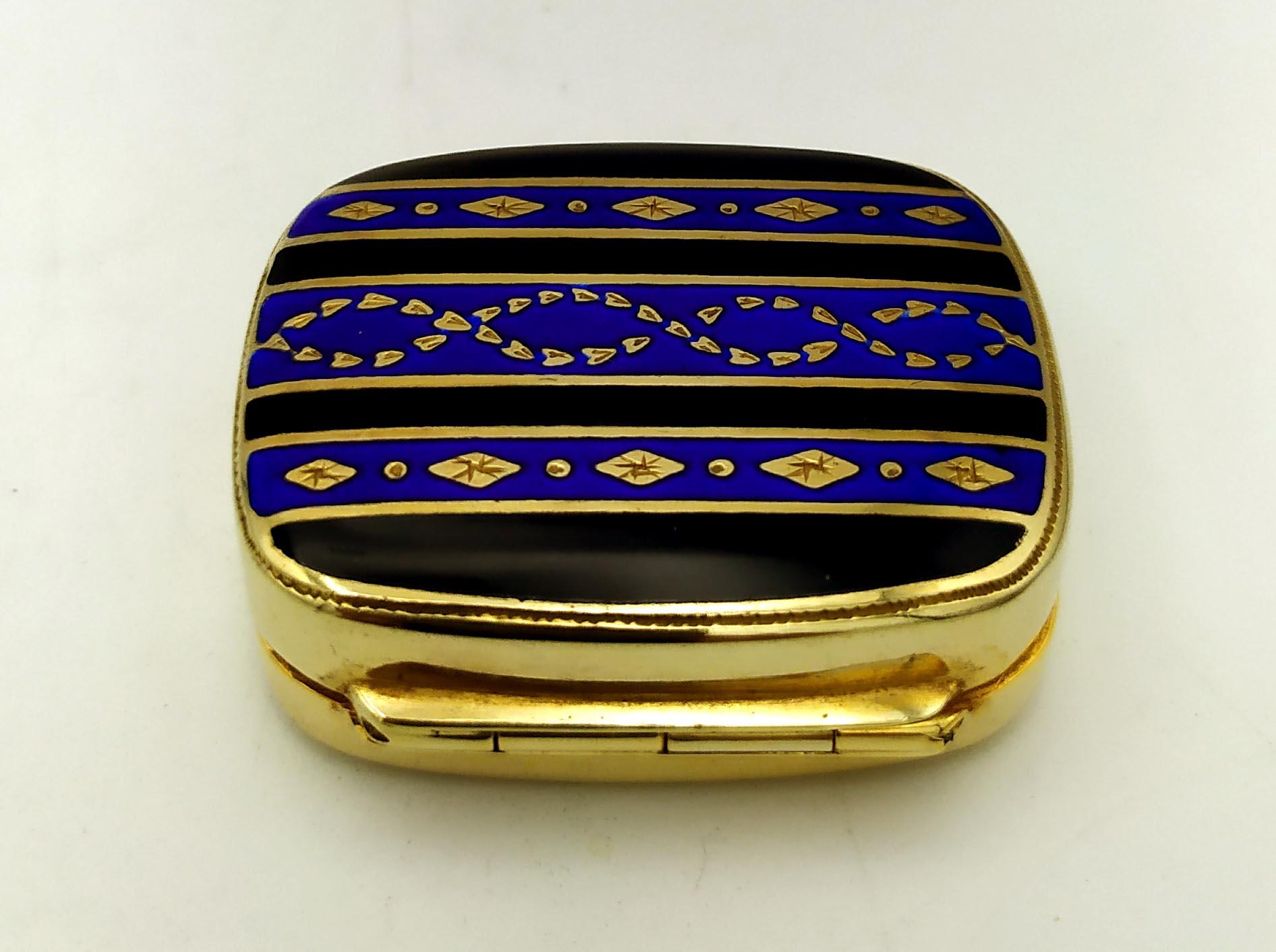 Lasciati sedurre dal fascino dell'arte vintage con questo portapillole rettangolare arrotondato, squisitamente realizzato in argento 925/1000 placcato oro. Adornato da intricate strisce smaltate a fuoco in stile Art Déco, questo pezzo misura 3,5 x