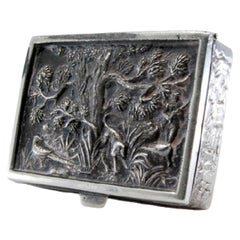 Pill box in embossed silver with animal motifs and gold interior with hinged lid