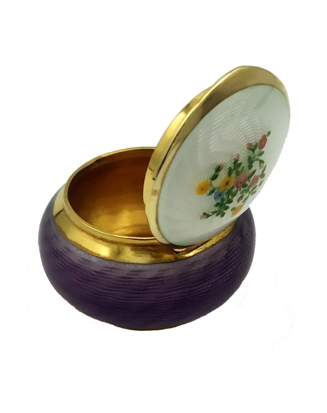Round pillbox in 925/1000 sterling silver gold plated with translucent fired enamel on guillochè and hand-painted floral miniature on the lid. Viennese Art Nouveau style. Diameter cm. 4.7 cm high. 3.1 weight gr. 64. Produced in the headquarters of