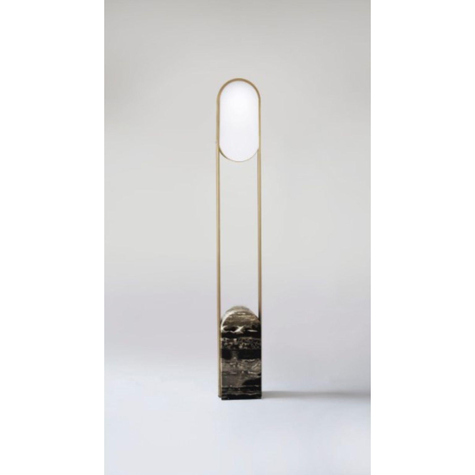 Pill floor lamp by Square in Circle
Dimensions: D 14 x W 20 x H 145 cm
Materials: Brushed brass/ black marble/ white frosted glass
Other finishes available.

A minimal floor lamp with a rounded block marble base. Brushed brass bands curve