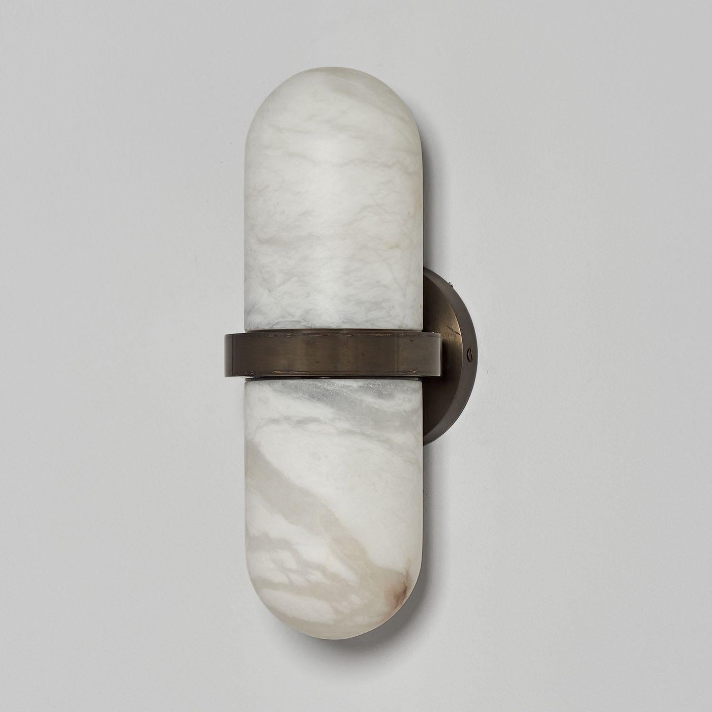 The Pill wall sconce has been conceived and developed in collaboration with the architecture firm Droulers Architecture. It recalls a pill made of two alabaster parts which join thanks to the middle brass structure containing two E14 lightbulbs. Its