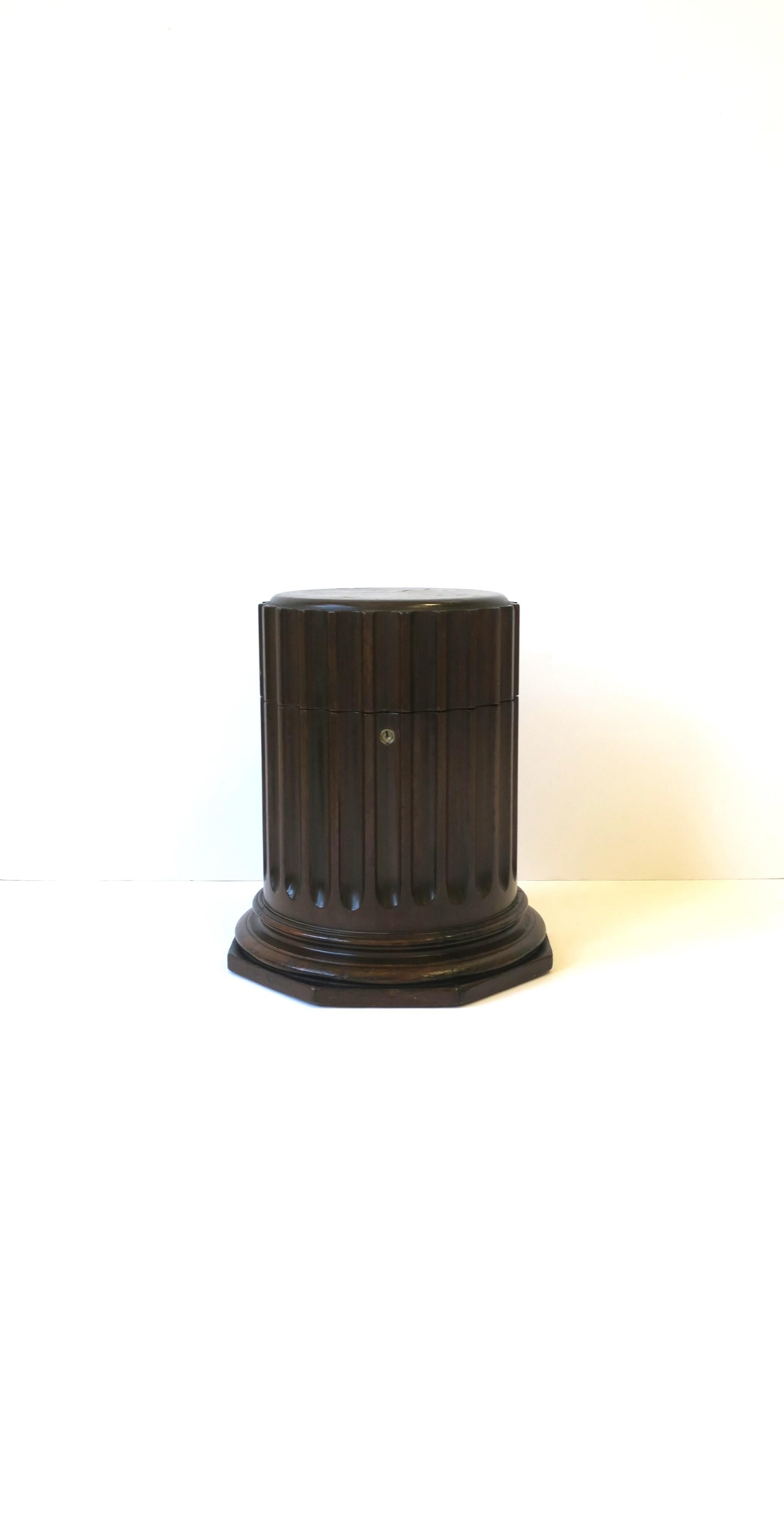 A beautiful column pedestal box in the neoclassical style, circa mid-20th century, USA. Piece is a rich dark brown wood with an octagonal base and fluted pillar. Box opens to an inside area that's also octagonal in shape with a Kelly-green hue. A