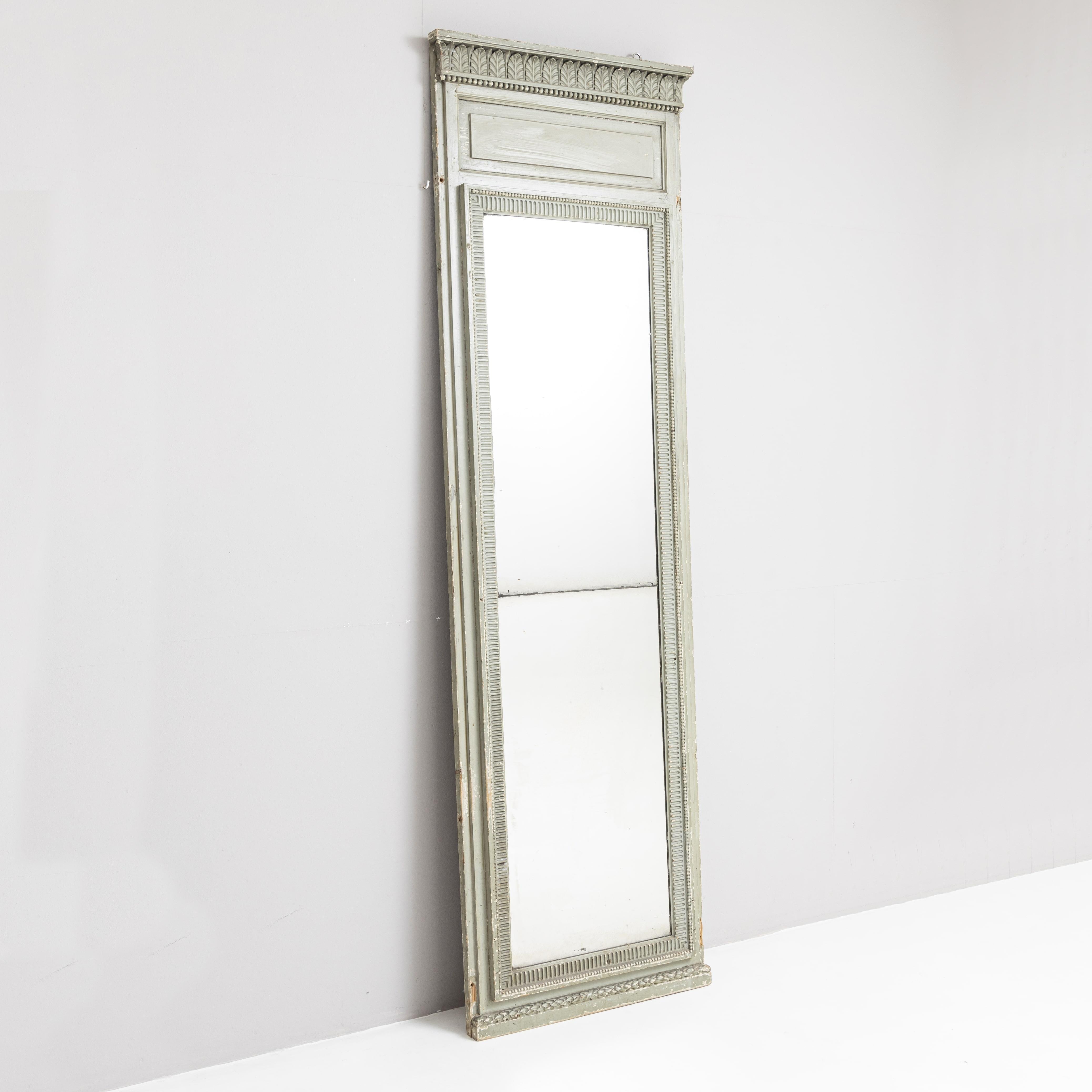 Large classicist pillar mirror in original light green paint with carved acanthus leaf and dentil decoration. The painting is rubbed in places.