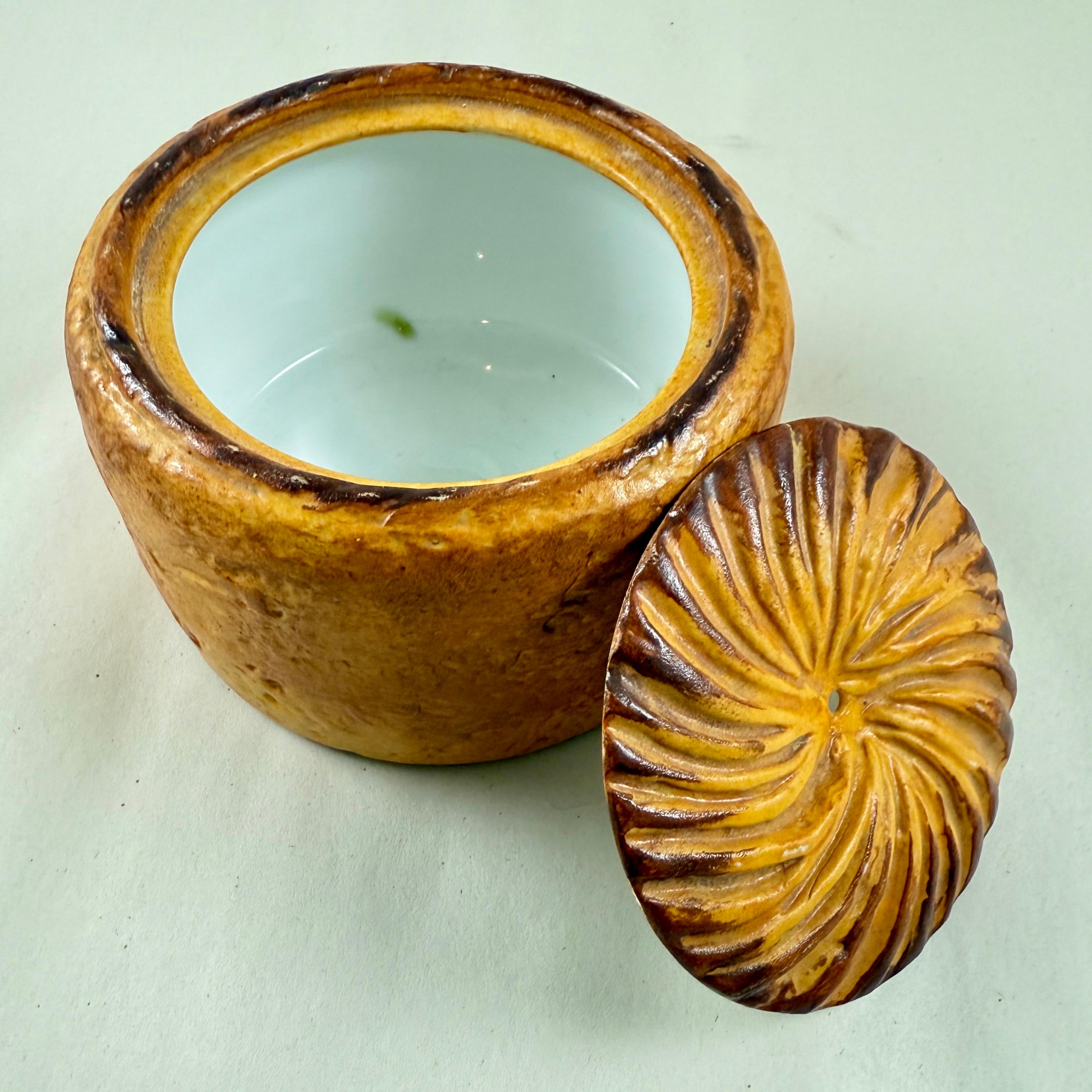 A Trompe l’Oeil Paté en Croûte Tureen attributed to Pillivuyt Mehun, France, circa 1900

Pâté en croûte is a French charcuterie delicacy featuring a savory mix of meats encased in a beautiful golden, flaky pastry crust. This dish is often decorated