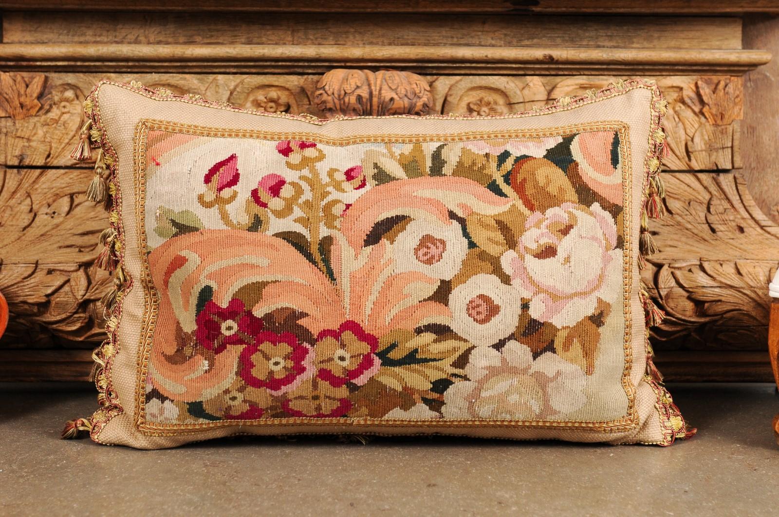 Un cuscino realizzato con una tappezzeria francese del XIX secolo, con decorazioni floreali e nappe. Ricavato da un arazzo tessuto nel XIX secolo, questo cuscino orizzontale è ornato da un'abbondante decorazione di fiori rosa e bianchi accentati da