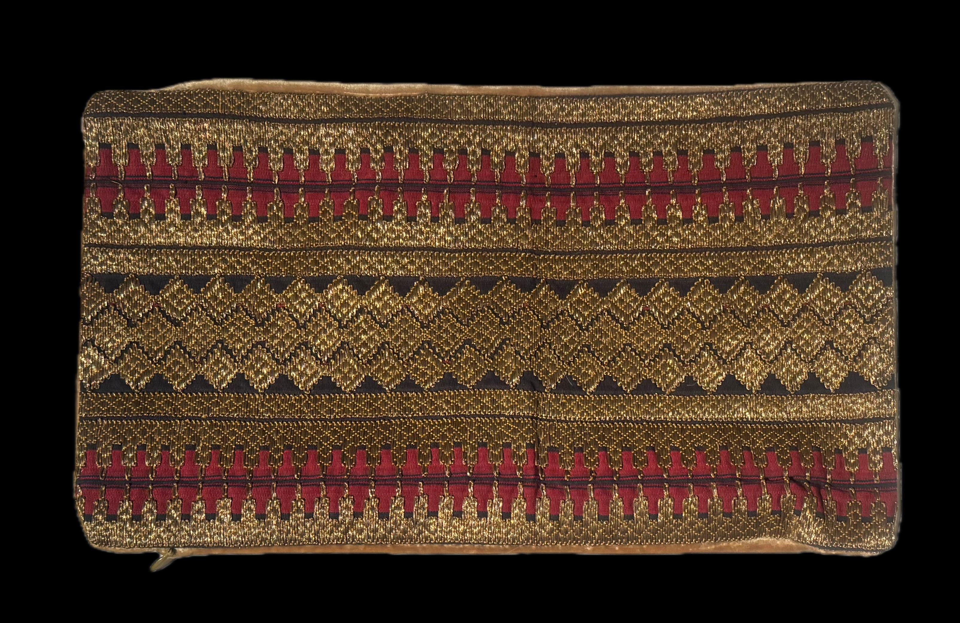 Fabriqué à partir d'un tissu indonésien ancien, cet oreiller lombaire est inhabituel et rare. Fabriqué à partir d'un brocart géométrique d'Asie du Sud-Est en fils d'or, coton rouge et noir. Un velours de soie contemporain de couleur or est utilisé