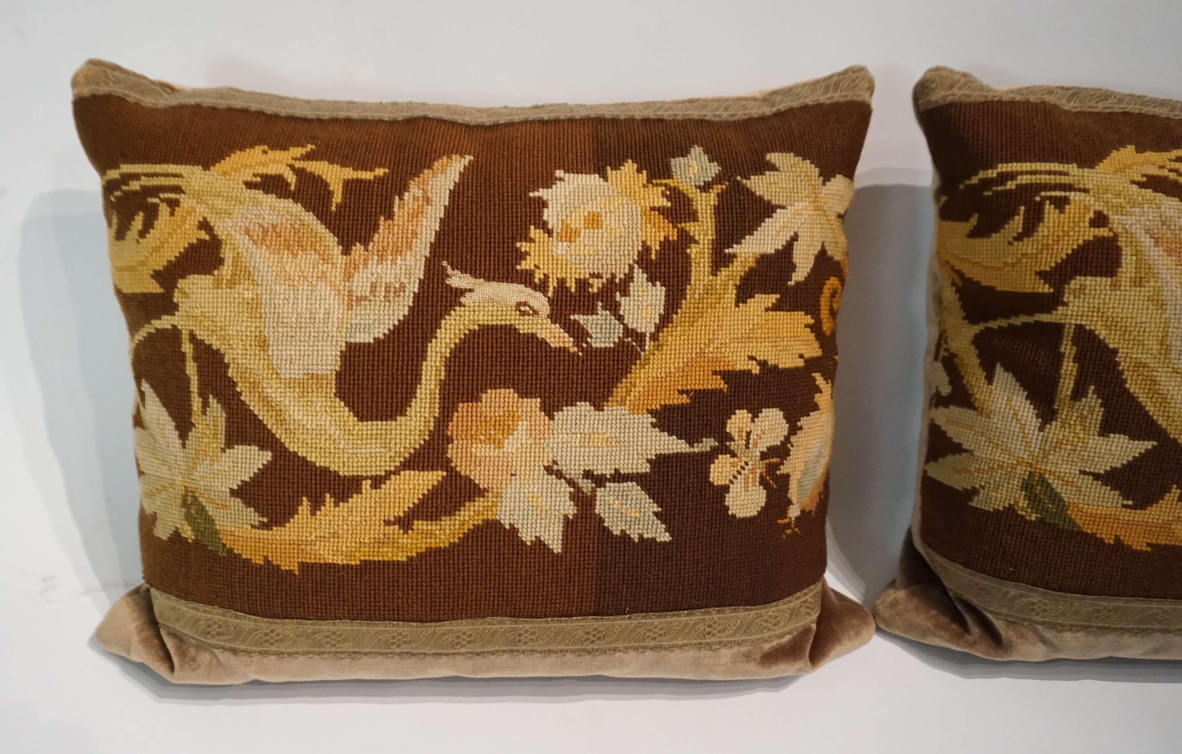Beautiful pair of newly made pillows or cushions having antique circa 1860 English Berlin wool work embroidered fronts with foliate, 'ho ho bird', and butterfly pattern with antique metallic gold passementerie trim borders on cotton strie velvet.