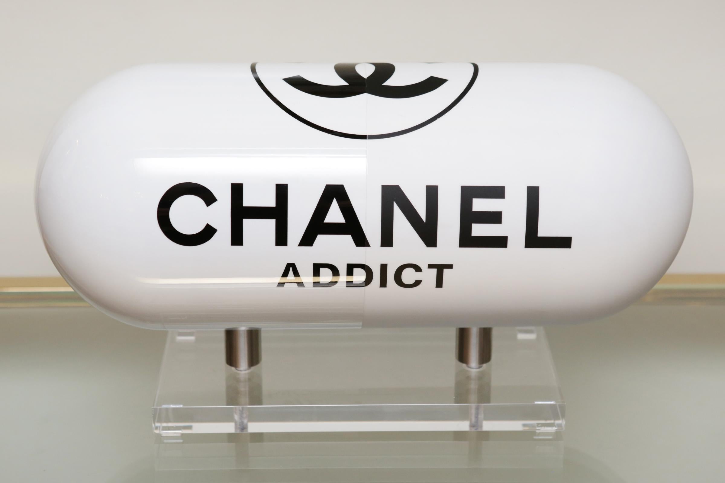 Sculpture Pill Chanel addict white in resin
with one side in glossy white finish and
one side in matte white finish. On plexiglass
acrylic base. Numberded 3/8.
Limited edition of 8 pieces.