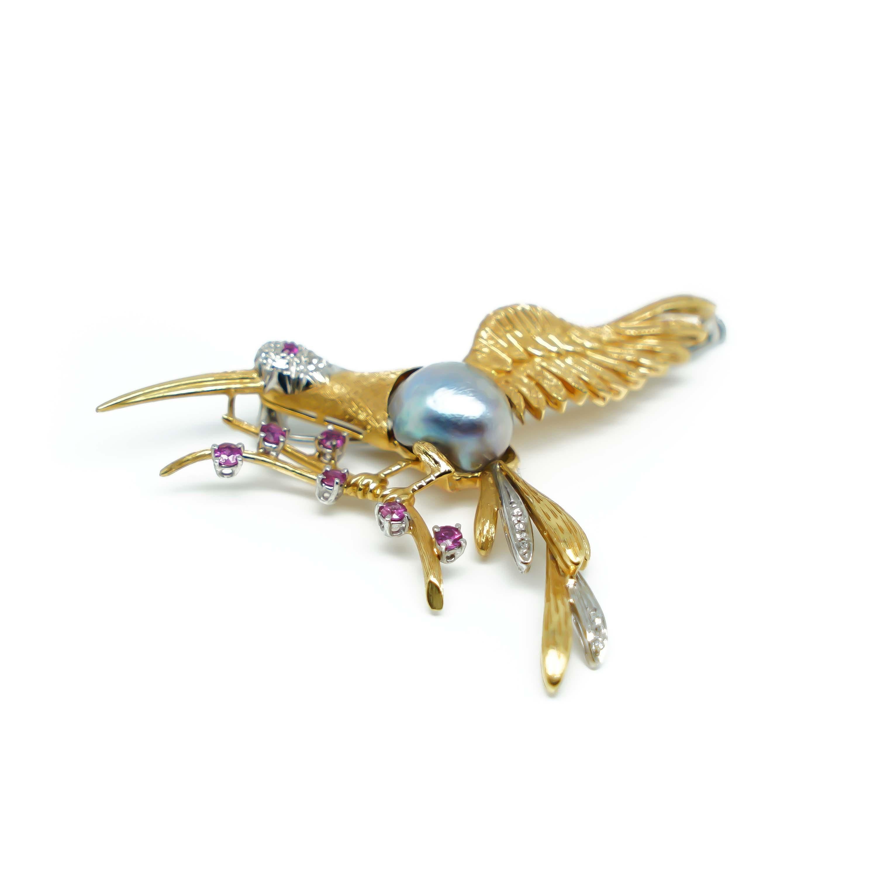 Pin Colibrì in Yellow and detailed White Gold 18 karats and Rubies, Diamonds and a central grey Pearl. It's a piece that has a strong and Original Design with a beautiful detailed structure totally Handmade that makes it Unique and a real Piece of