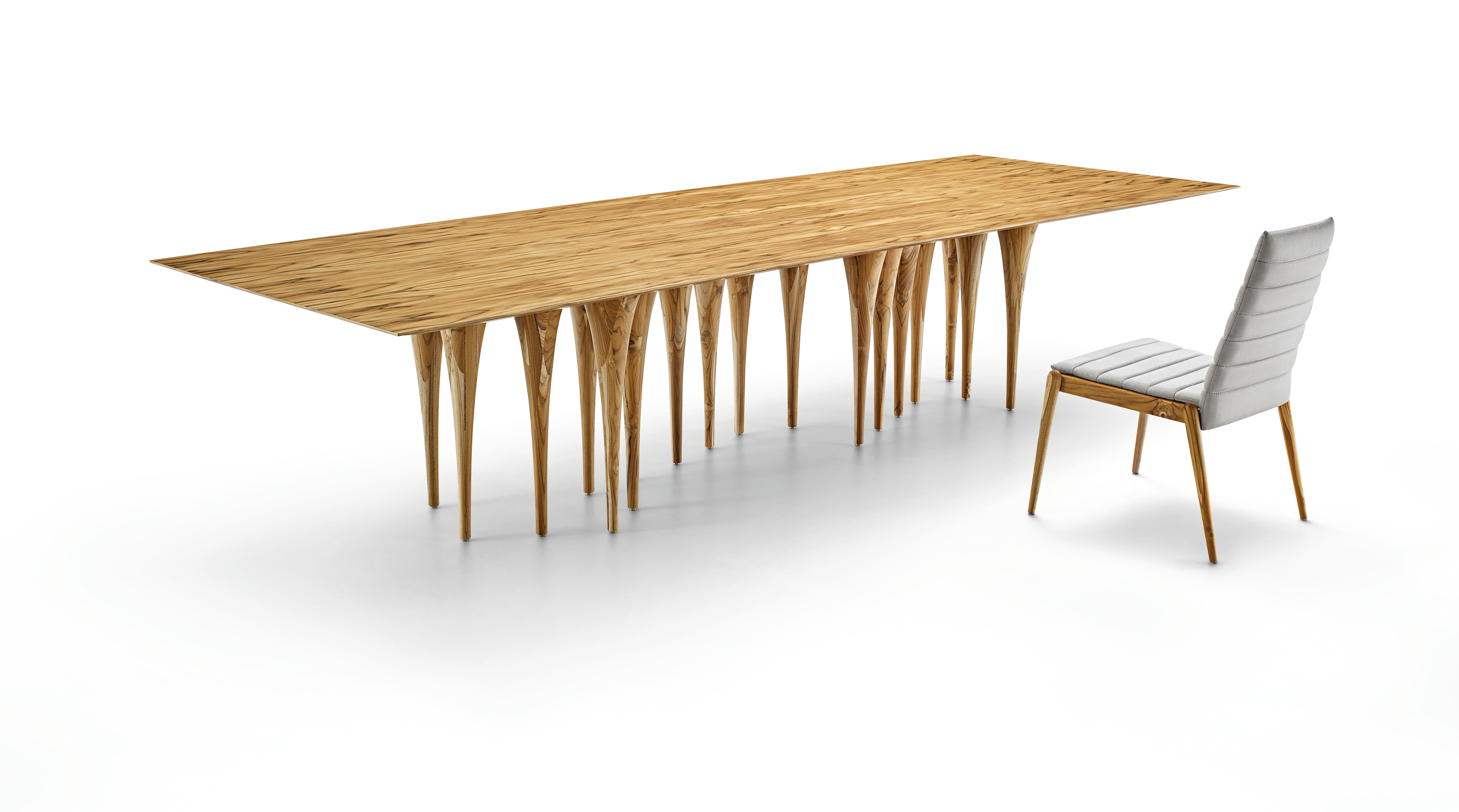 L'équipe d'Uultis a créé cette table Pin rectangulaire en bois de teck avec seize pieds, ce qui crée un impact surprenant au premier coup d'œil. Elle a une structure très singulière et originale qui rappelle les couloirs des châteaux gothiques, mais