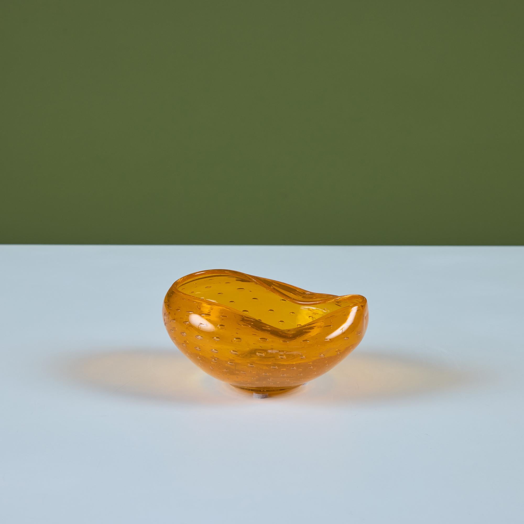 Coupe en verre à bulles pincées, de forme libre. Ce bol en verre de style Murano présente un verre bulle orange avec deux côtés pincés. Cette pièce sculpturale peut être utilisée comme vide-poche, bol décoratif ou cendrier.

Dimensions
5,5