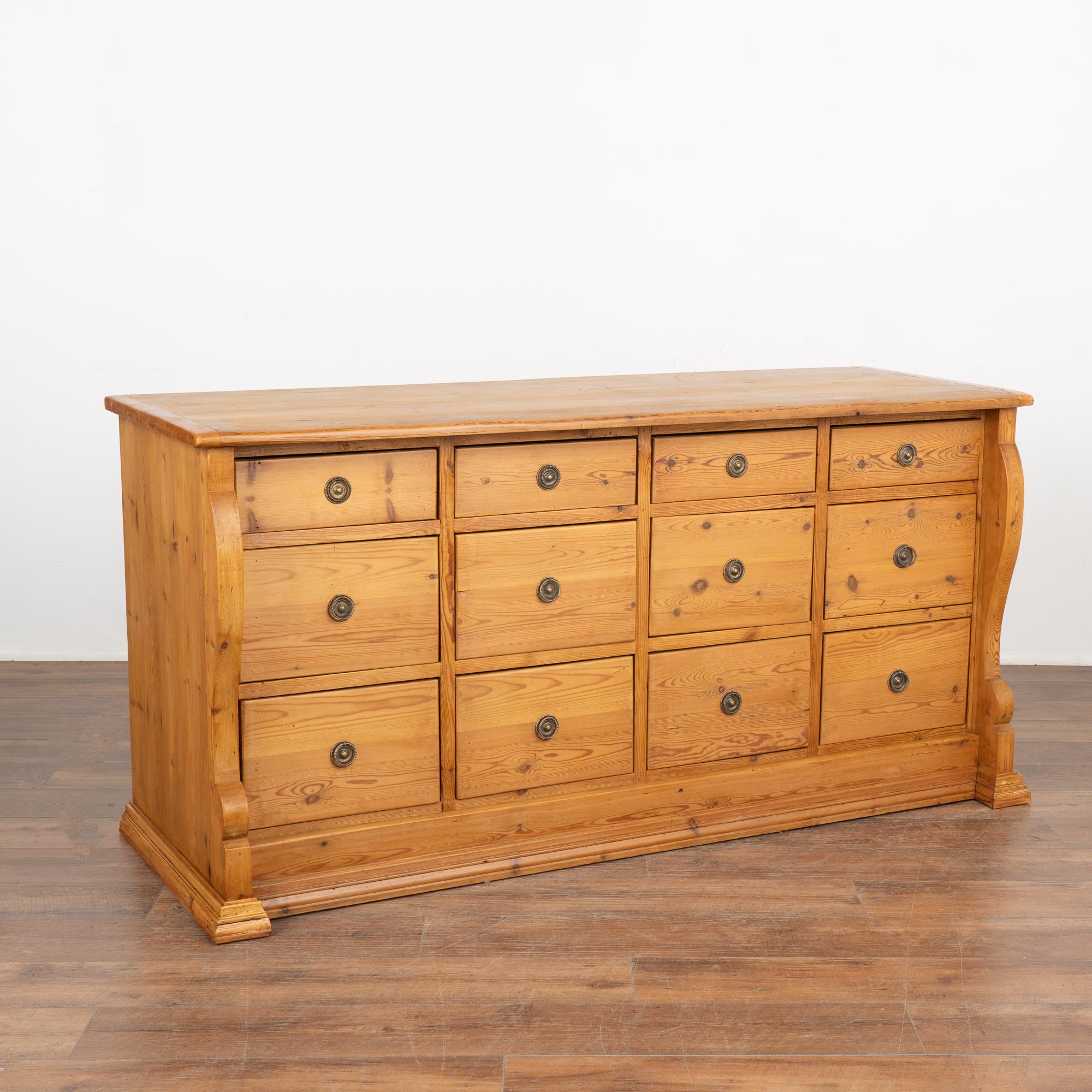 Fun and function combine in this pine chest of 12 drawers. This delightful pine apothecary originally served as a shop counter or storage cabinet. Counters similar to this were used throughout shops in European and are a great way to incorporate old