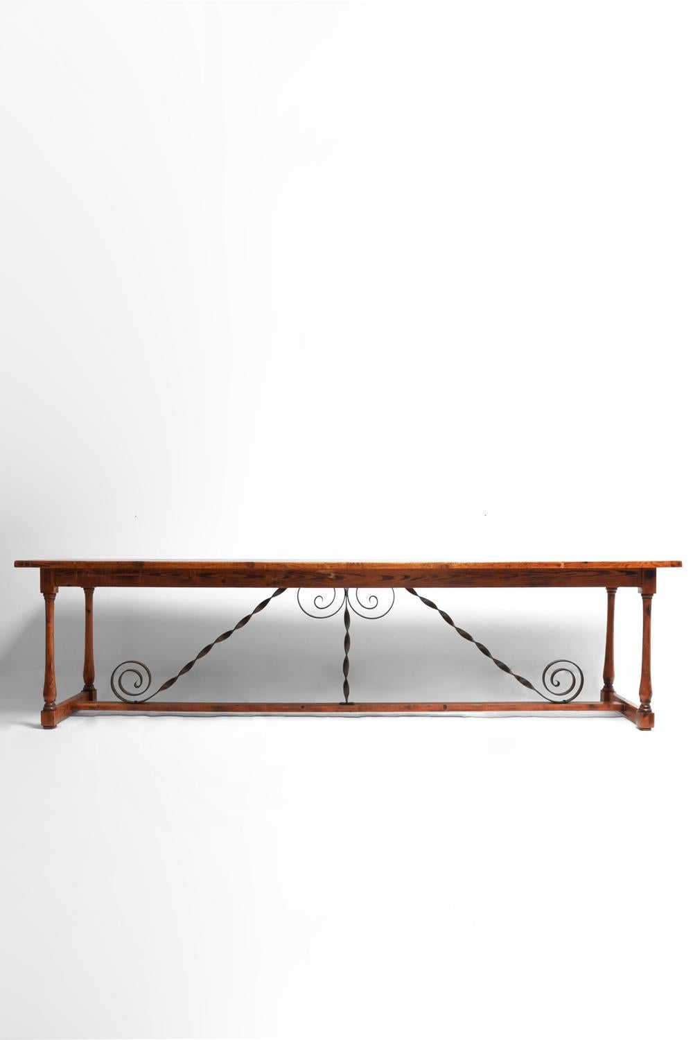 Pine and ironwork dining table, console resting on four columnar legs joined by a spacer topped with ironwork. Spain, 1910s.