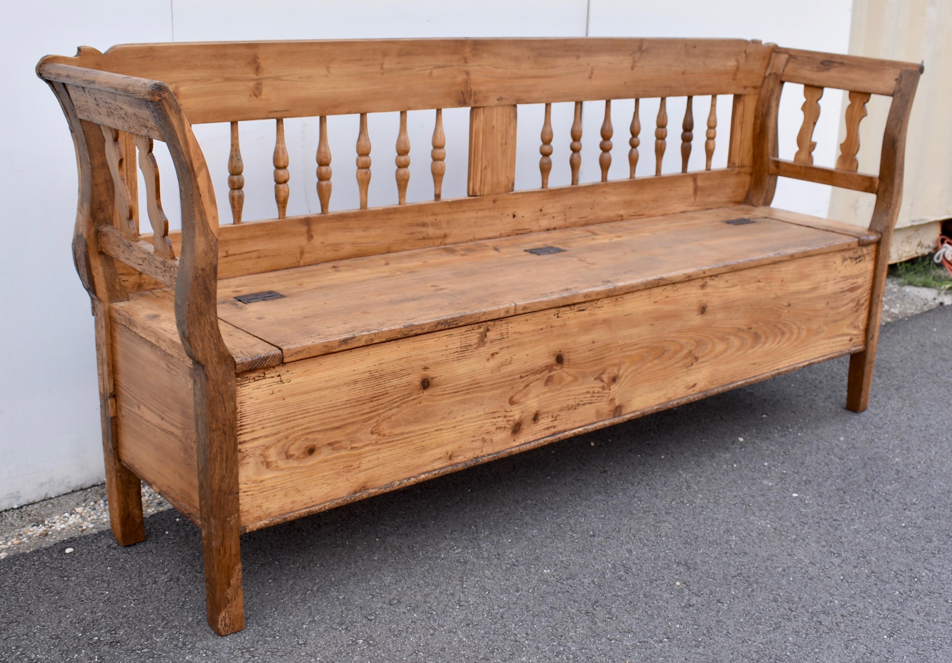 This long storage bench has a few details that set it apart from many of the rest.  Its size is impressive and so is its form.  The otherwise flat back top rail has a little “flick” at each end that emphasizes the scroll at the top of the arms.  A