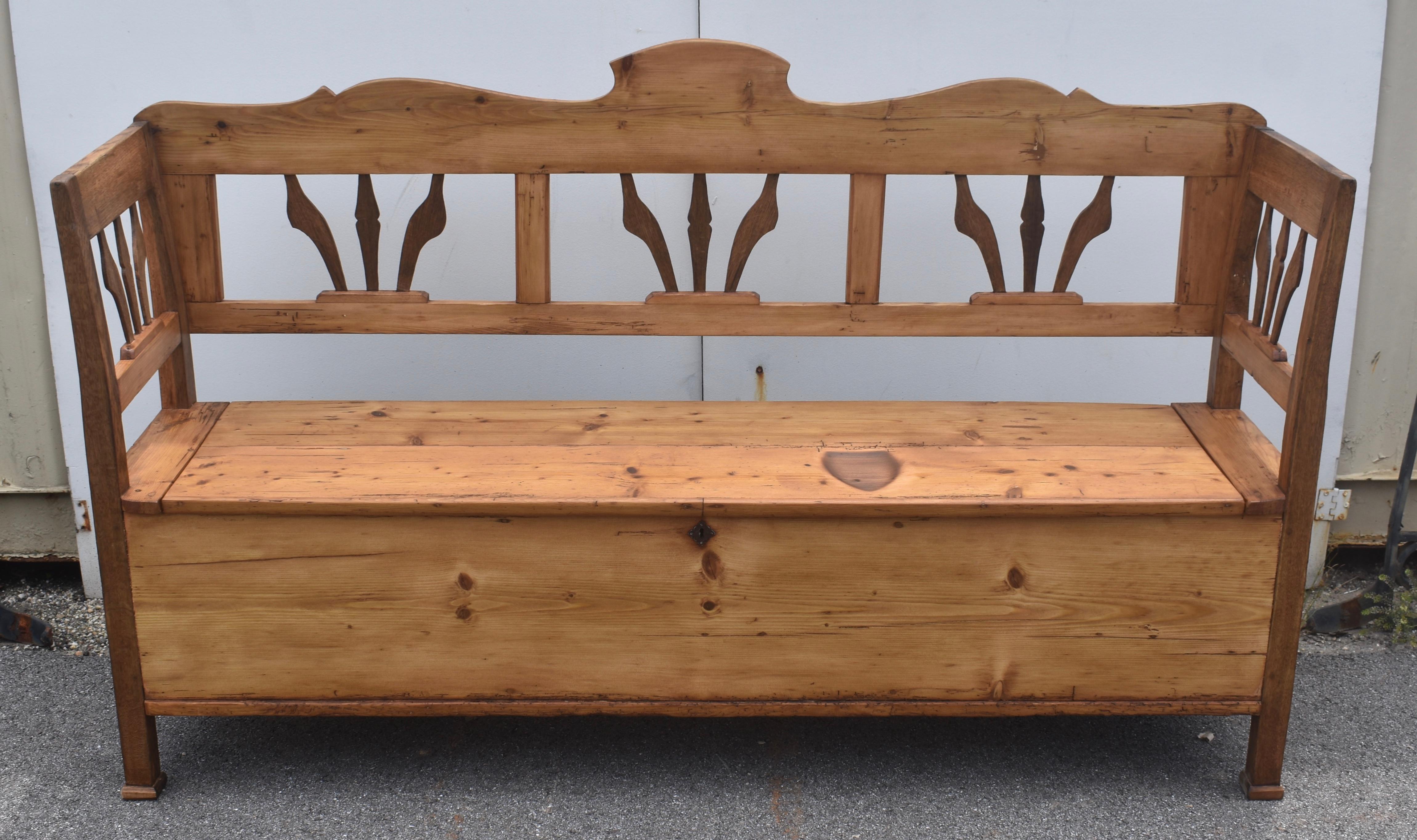 This handsome box bench has lots of character with one major unintentional feature.  It’s hard to ignore the neat smoothing iron burn on the right hand front of the seat.  The scalloped top rail peaks at a crest in the center.  With the bottom rail