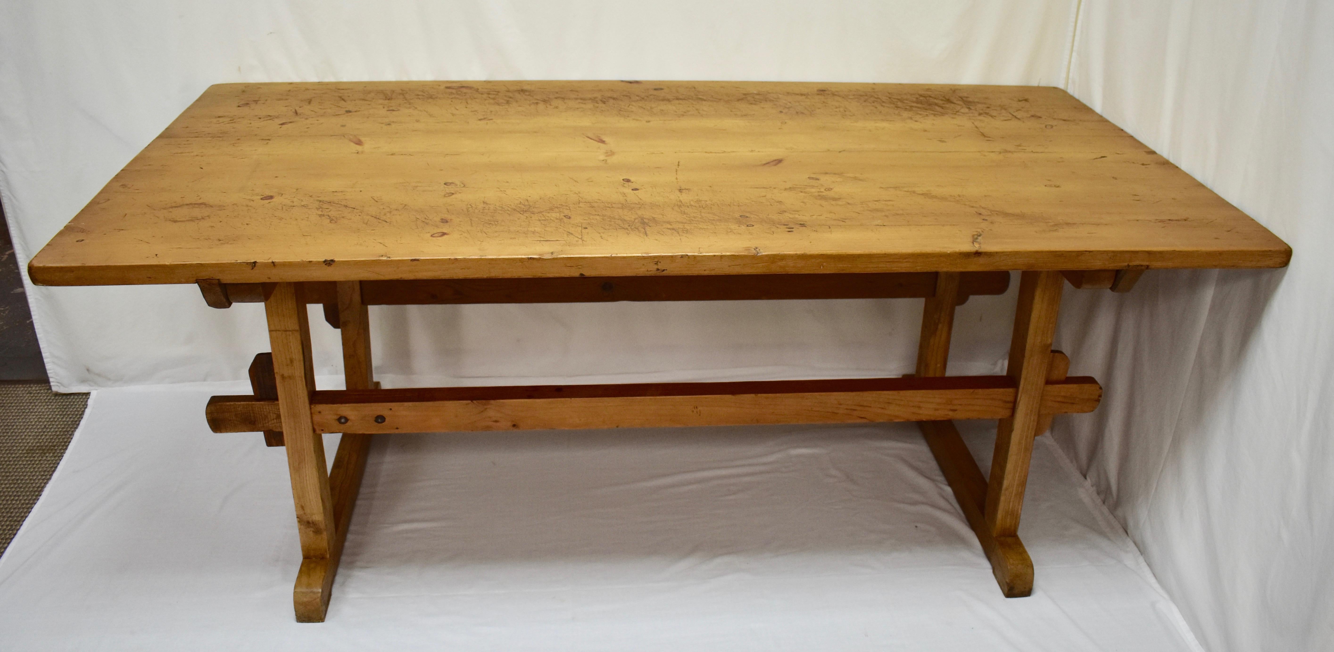This outstanding pine and oak trestle table has a three board pine top, the outside boards are 16” wide, with two sturdy cleats dovetailed into the underside which peg into the top rails of the base for stability. The trestle base itself is of oak