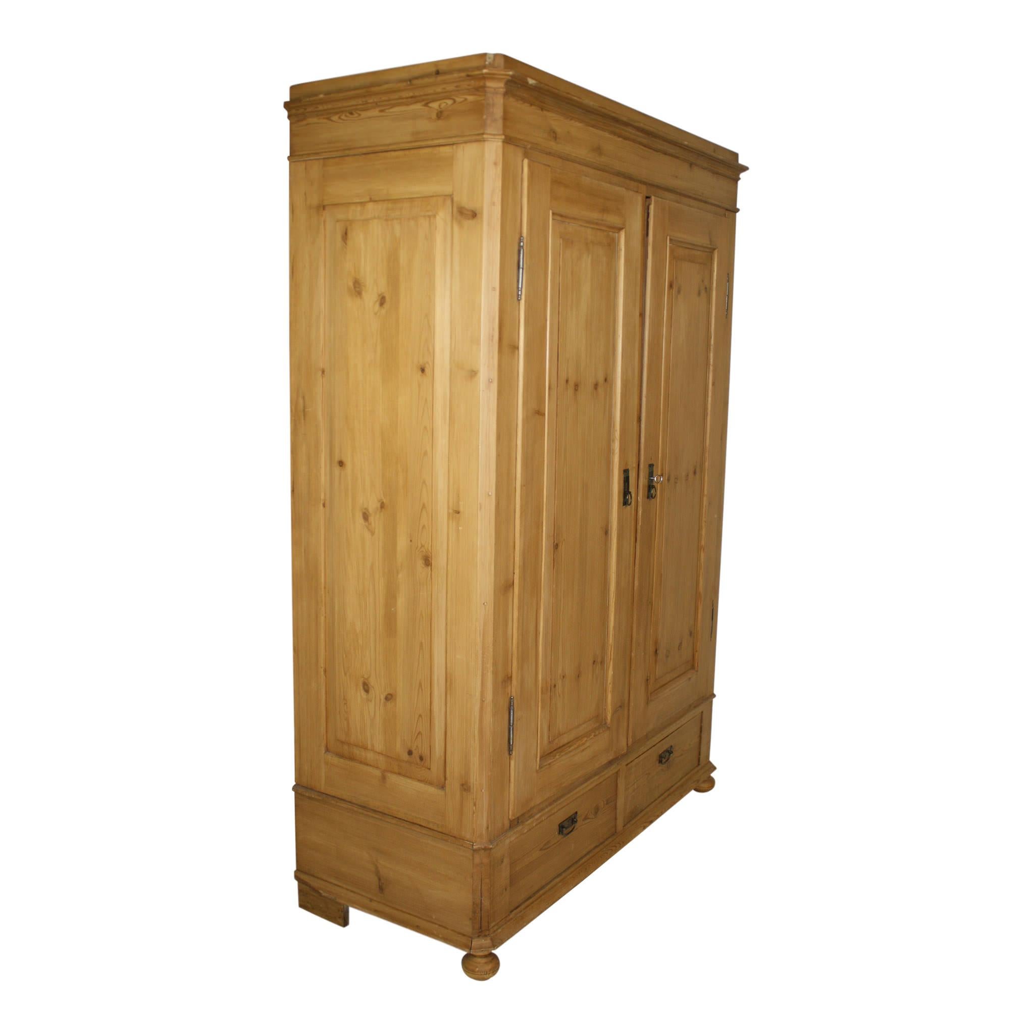 The simplicity of natural pine paired with a large footprint gives this armoire a look that is both warm and stately. Double doors open to a unique design of pegs along the back, sides, and crossbar. Two lower drawers provide additional storage. The