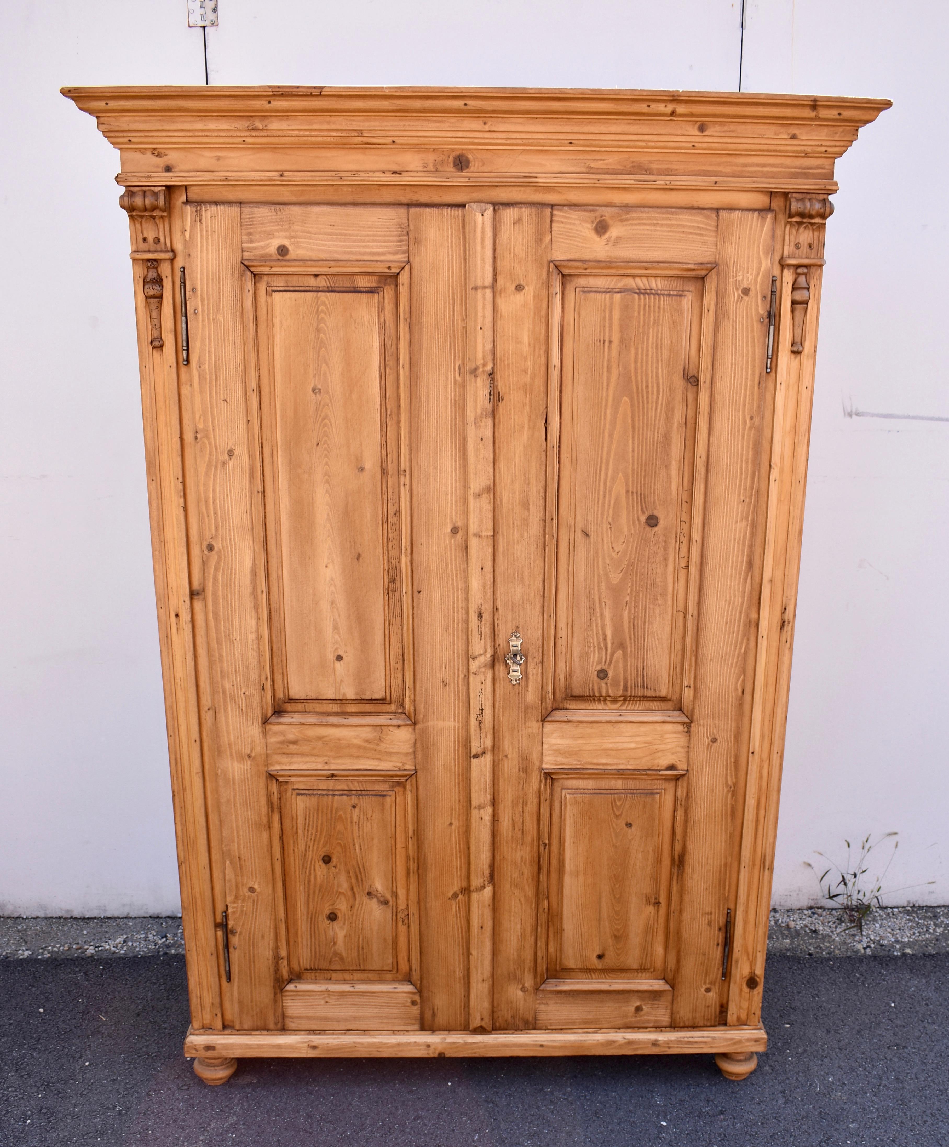 The wide crown of this handsome piece is built up with three tiers of molding including an attractive strip of reeding.  The two overlay doors each house two raised panels, one tall above one shorter.  The doors open on iron French style fiche